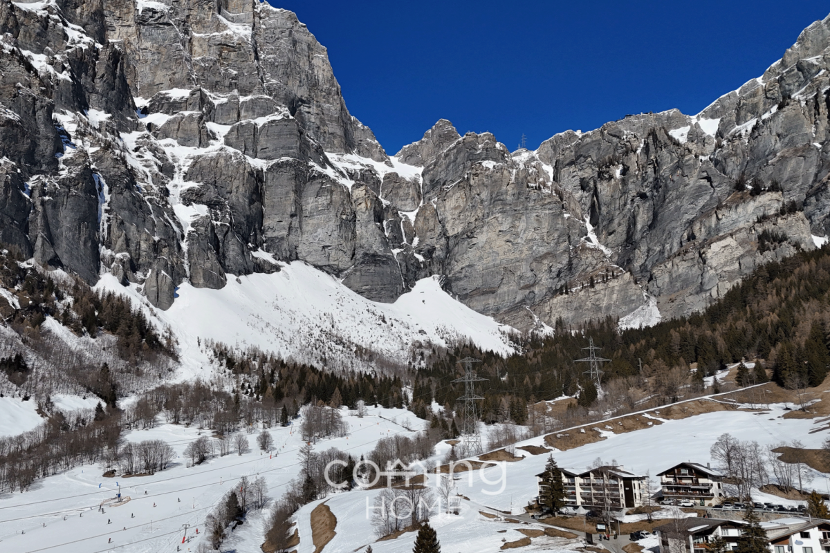 Alpenlandschaft mit Felswänden und Talbebauung