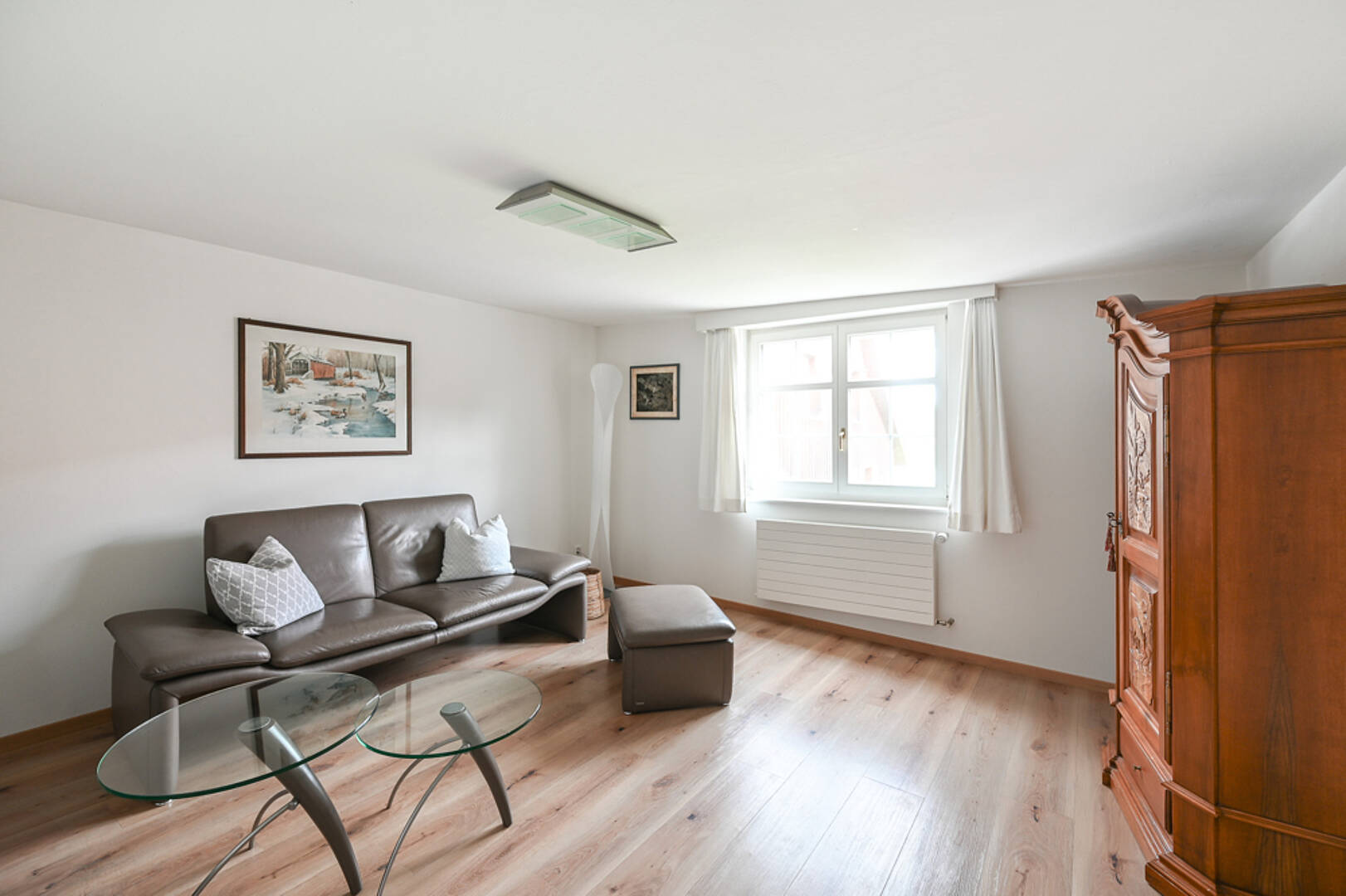 Helles Wohnzimmer mit Sofa und Holzschrank