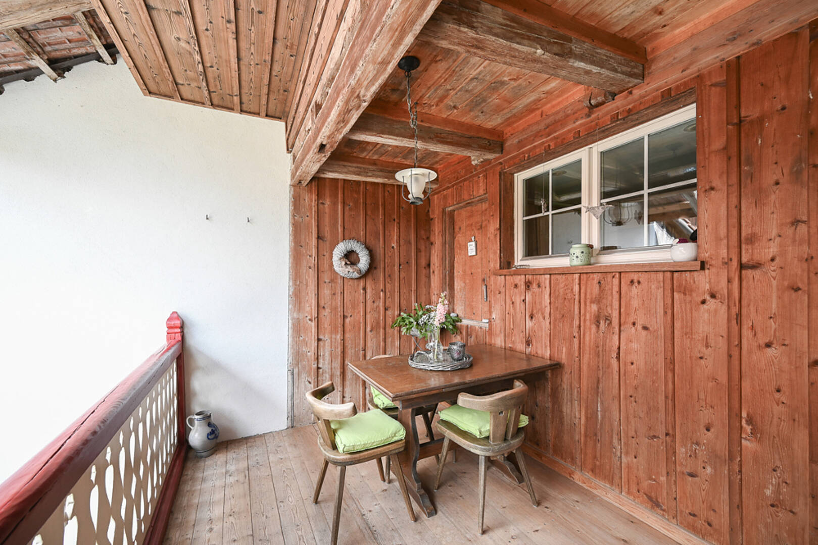 Gemütlicher Holzbalkon mit Sitzplatz