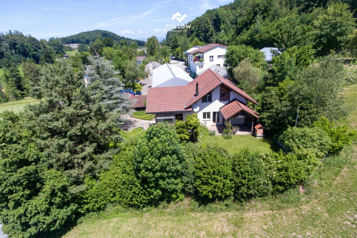 Luftaufnahme eines Wohnhauses in grüner Hanglage