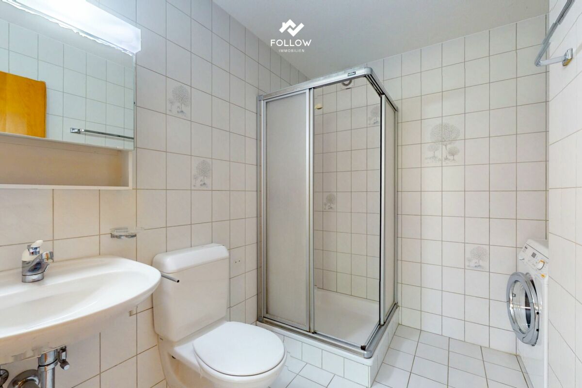 Badezimmer mit Dusche und Waschmaschine