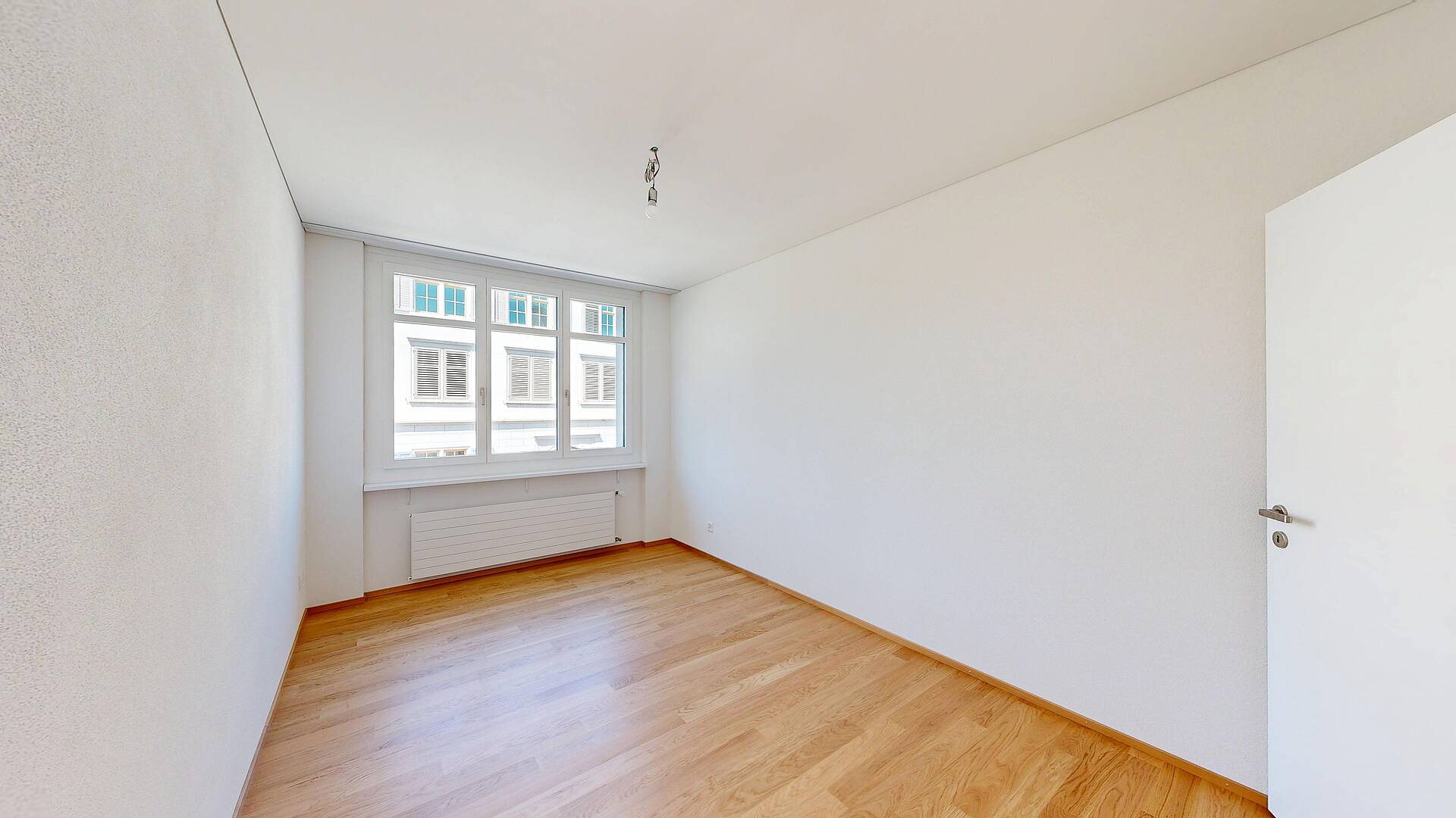 Leerer heller Wohnraum mit Parkettboden