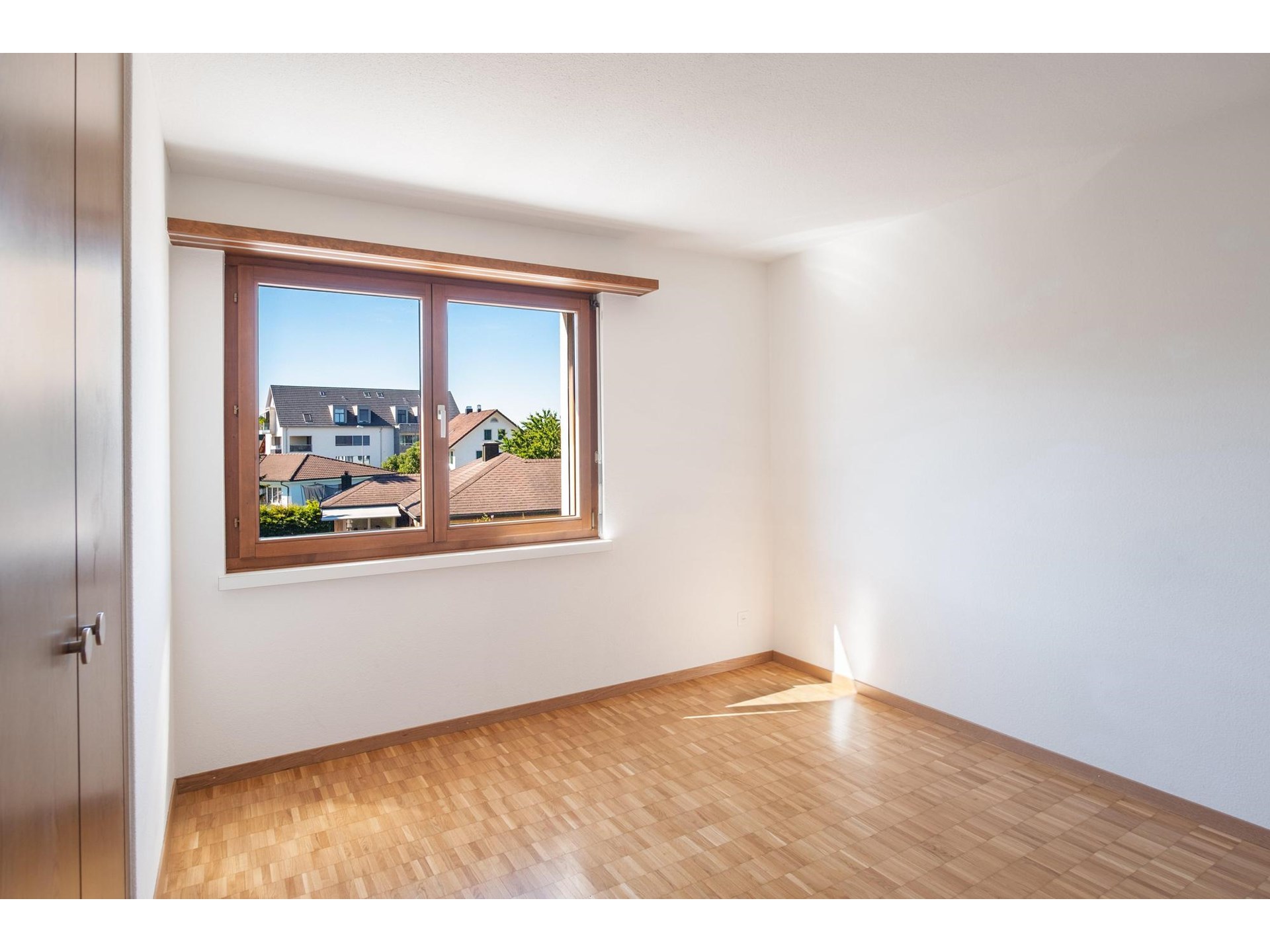 Helles, leeres Zimmer mit Holzfenster