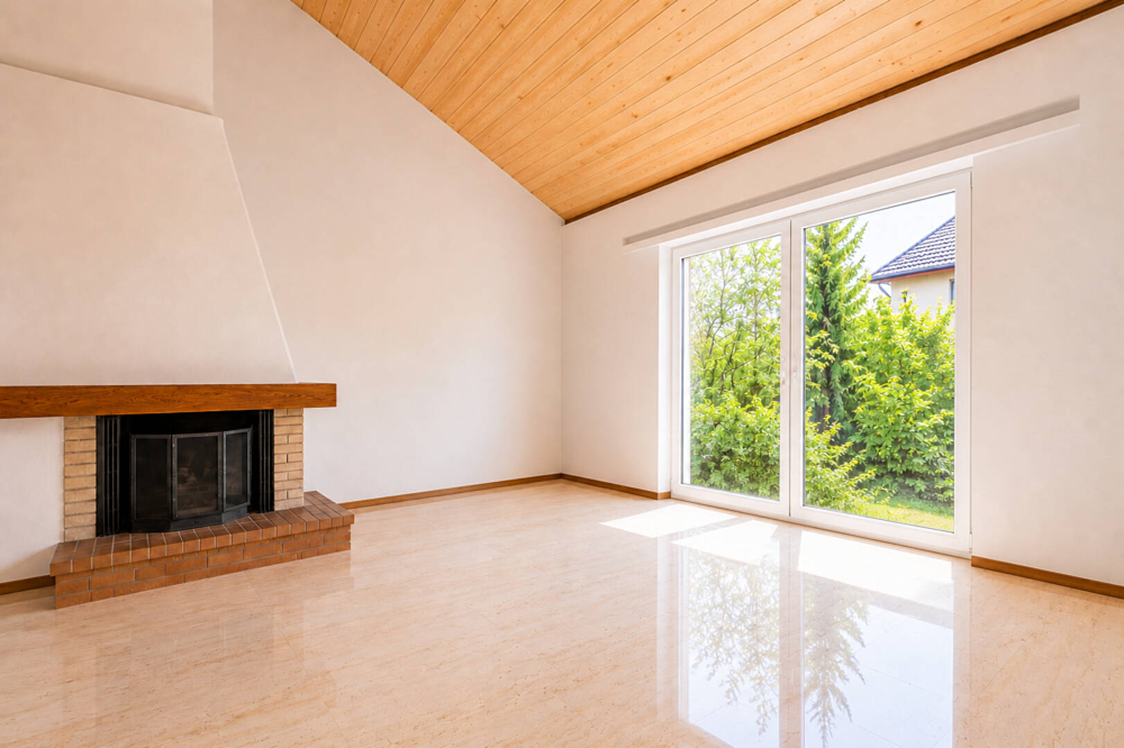 Wohnzimmer mit Kamin und Blick in den Garten
