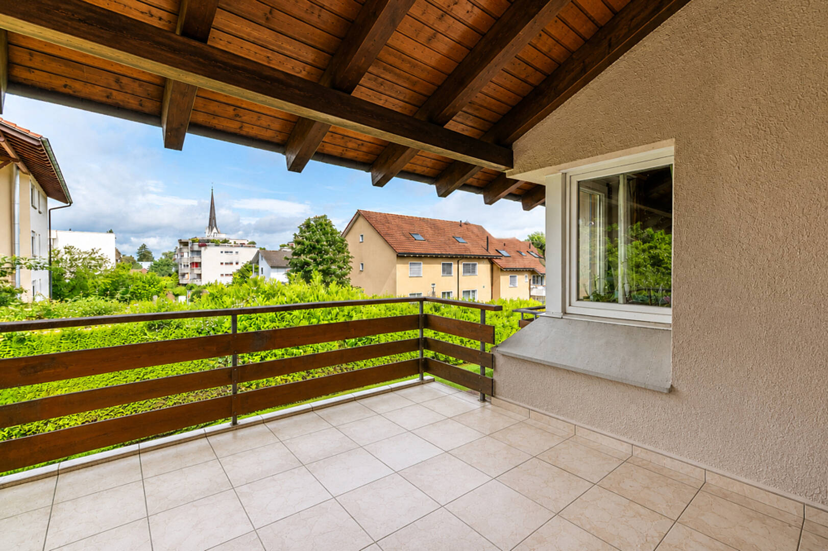Überdachter Balkon mit Blick ins Wohnumfeld