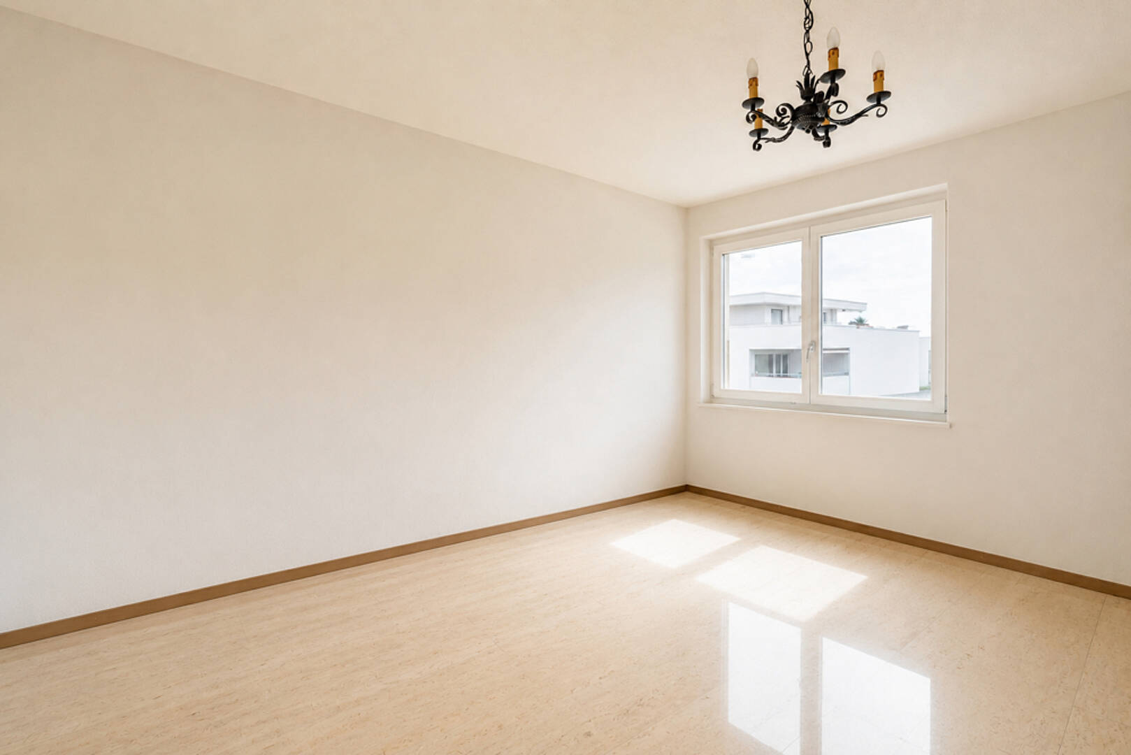 Heller leerer Raum mit Fenster und Deckenleuchte