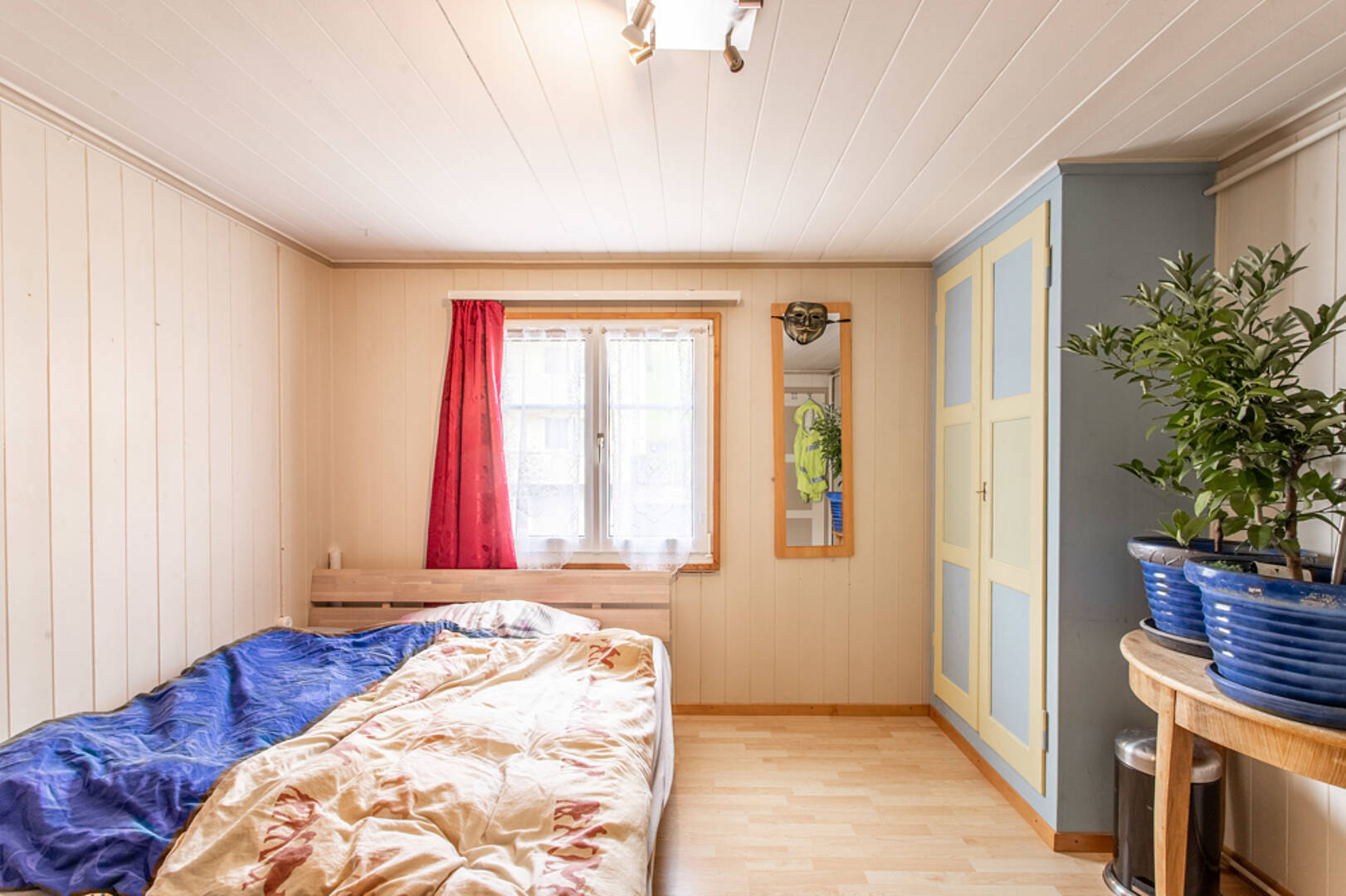 Gemütliches Schlafzimmer mit hellen Holzmöbeln und farbigen Akzenten