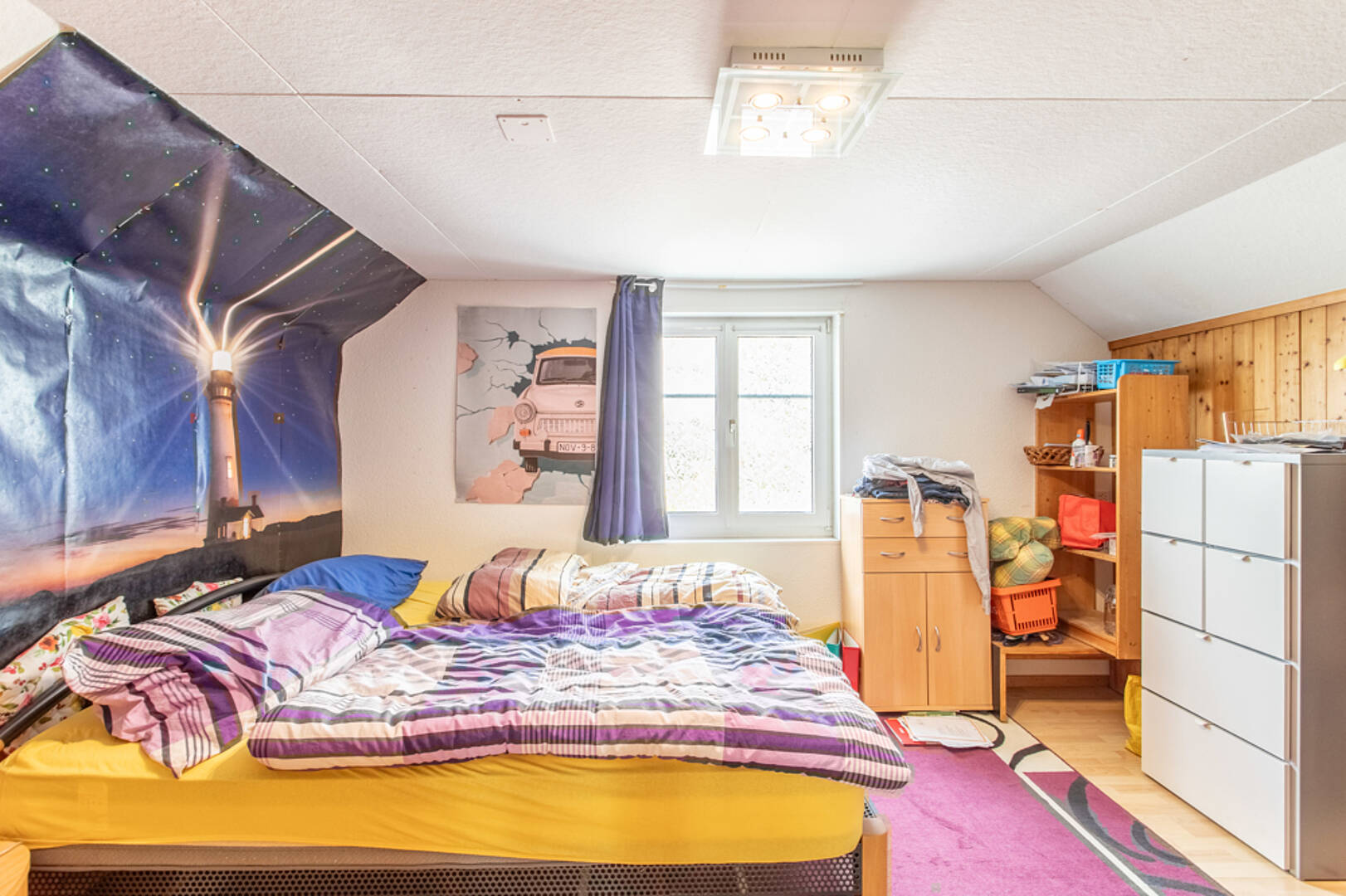 Gemütliches Dachzimmer mit Bett und viel Stauraum