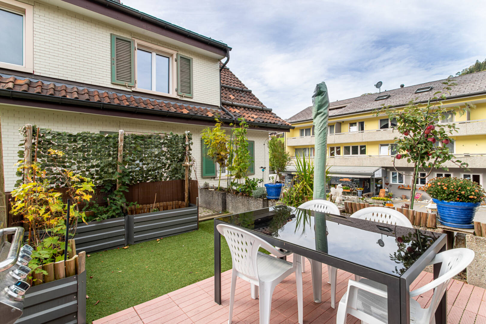 Terrasse mit Gartenmöbeln vor Wohngebäuden