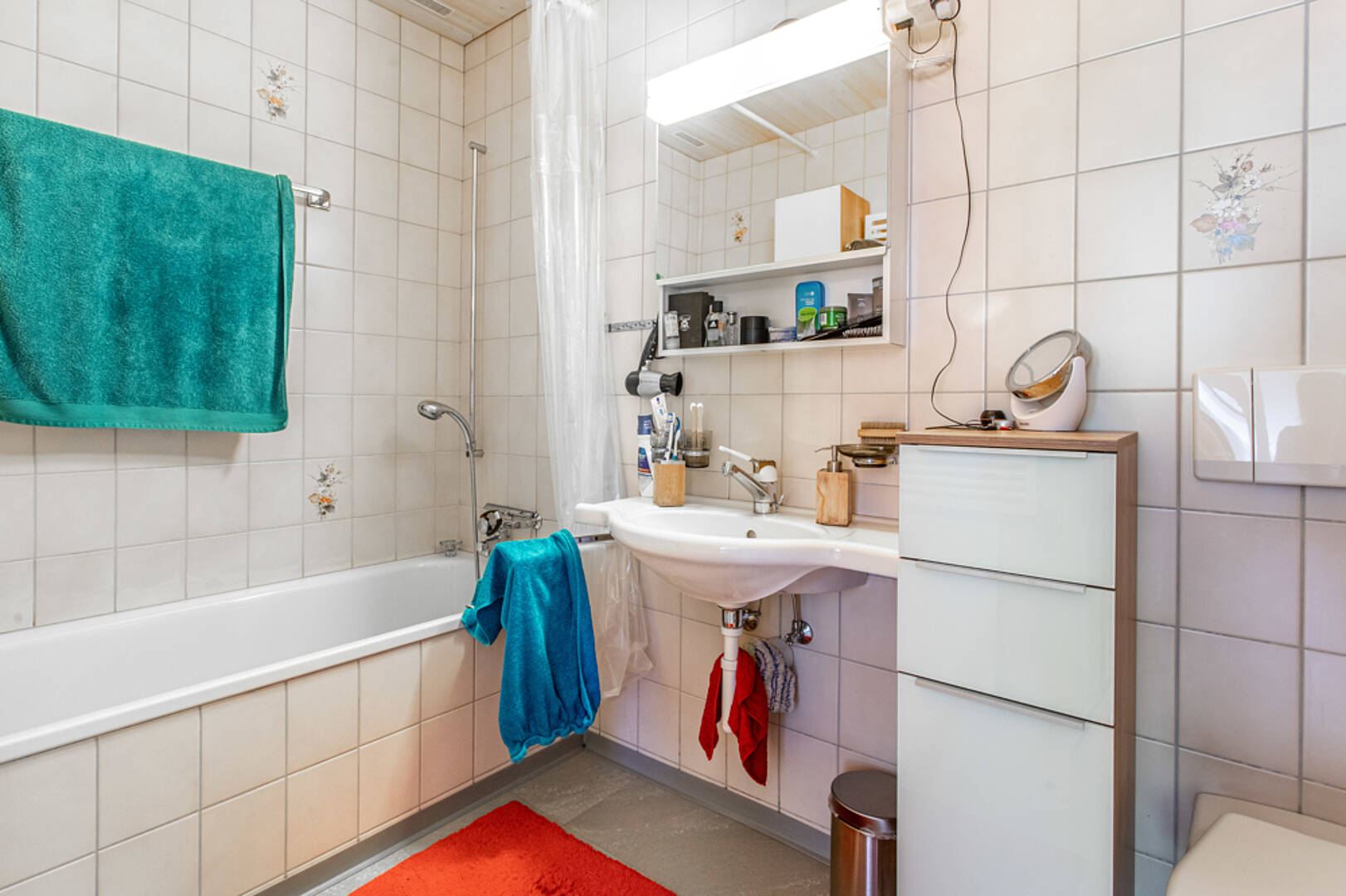 Kleines Badezimmer mit Wanne und Waschplatz