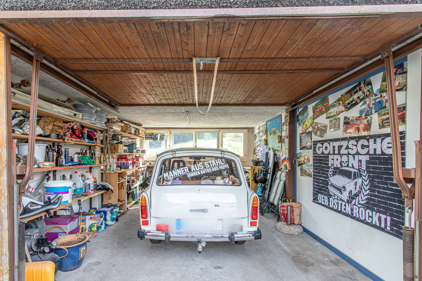 Garage mit geparktem Kleinwagen und vielen gelagerten Gegenständen