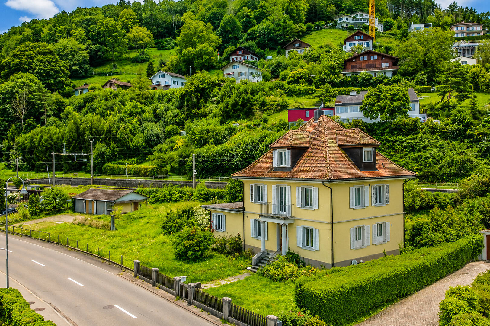 Haus in grüner Hanglage mit Alpenblick