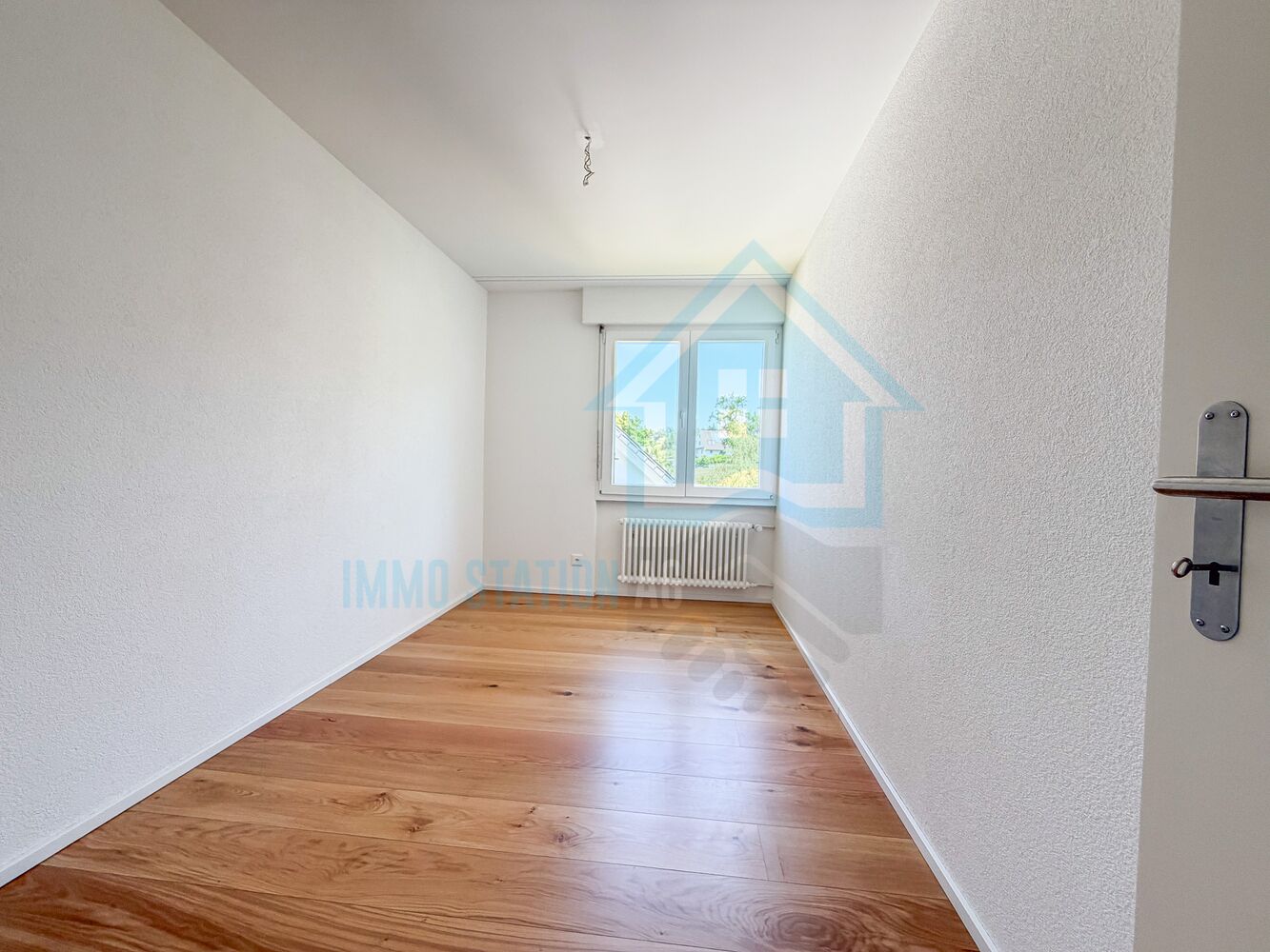 Heller leerer Raum mit Holzboden und Fenster