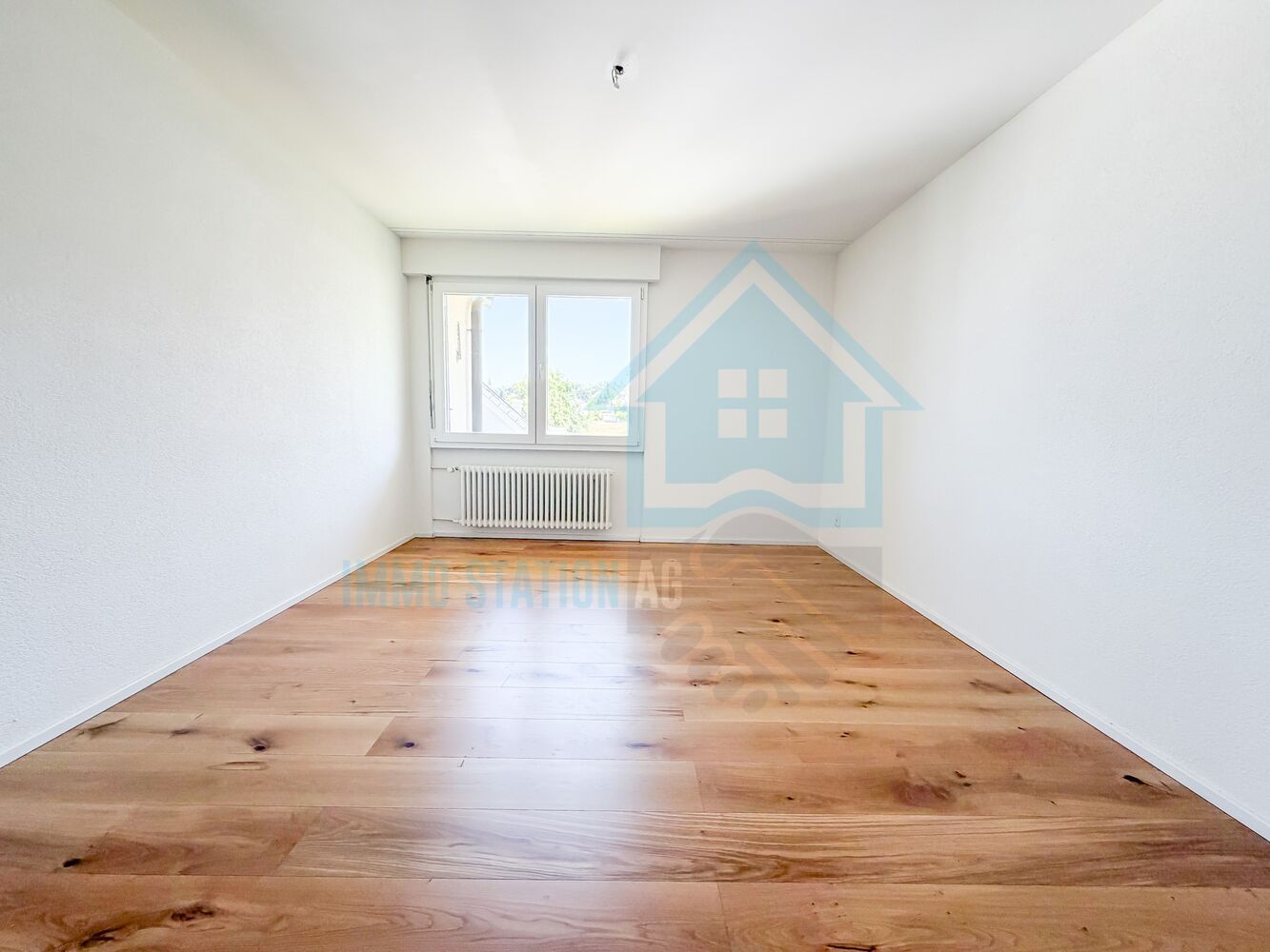 Leerer heller Raum mit Holzboden und Fenster