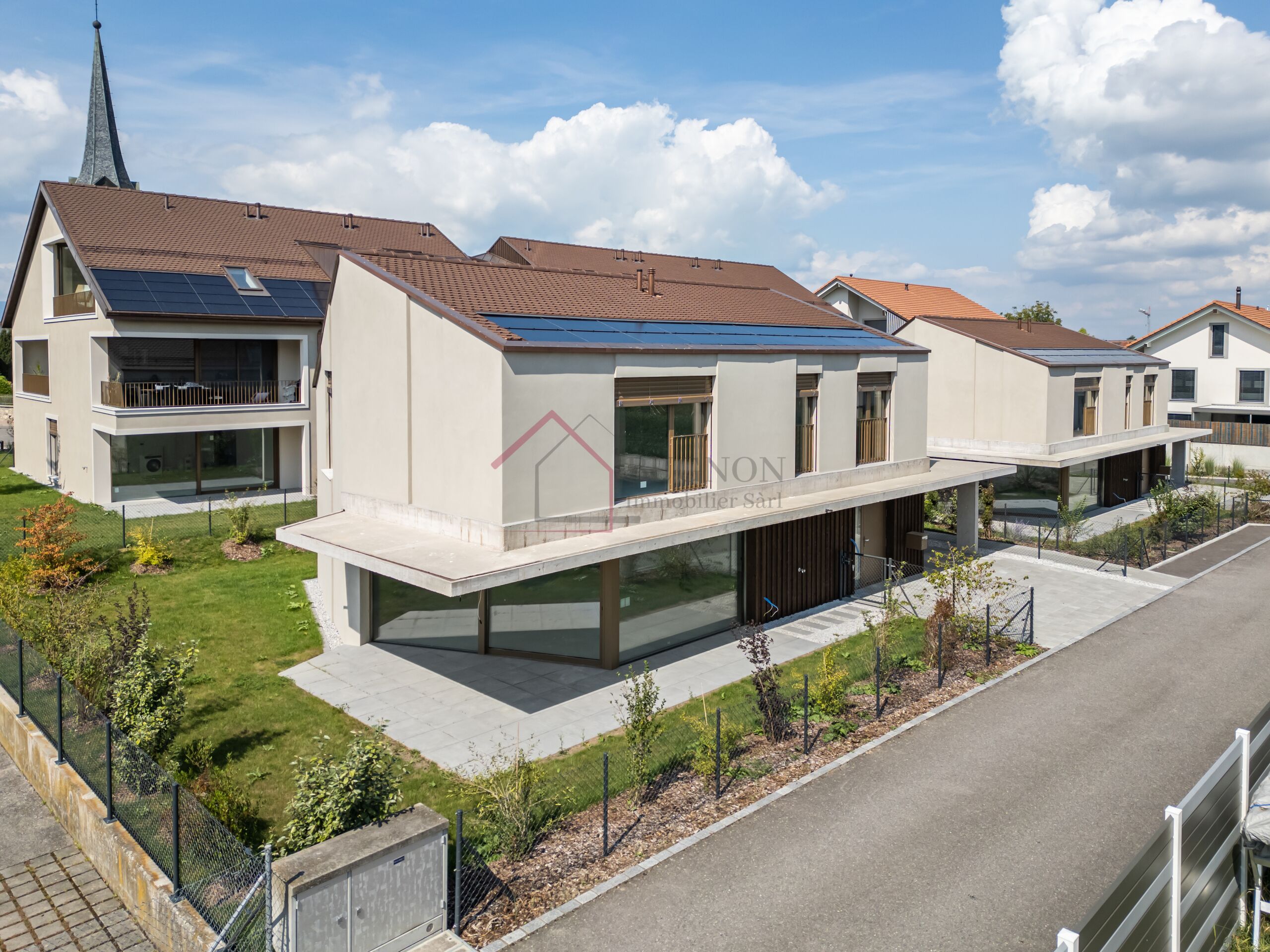 Moderne Wohnanlage mit Satteldächern und Solarpaneelen