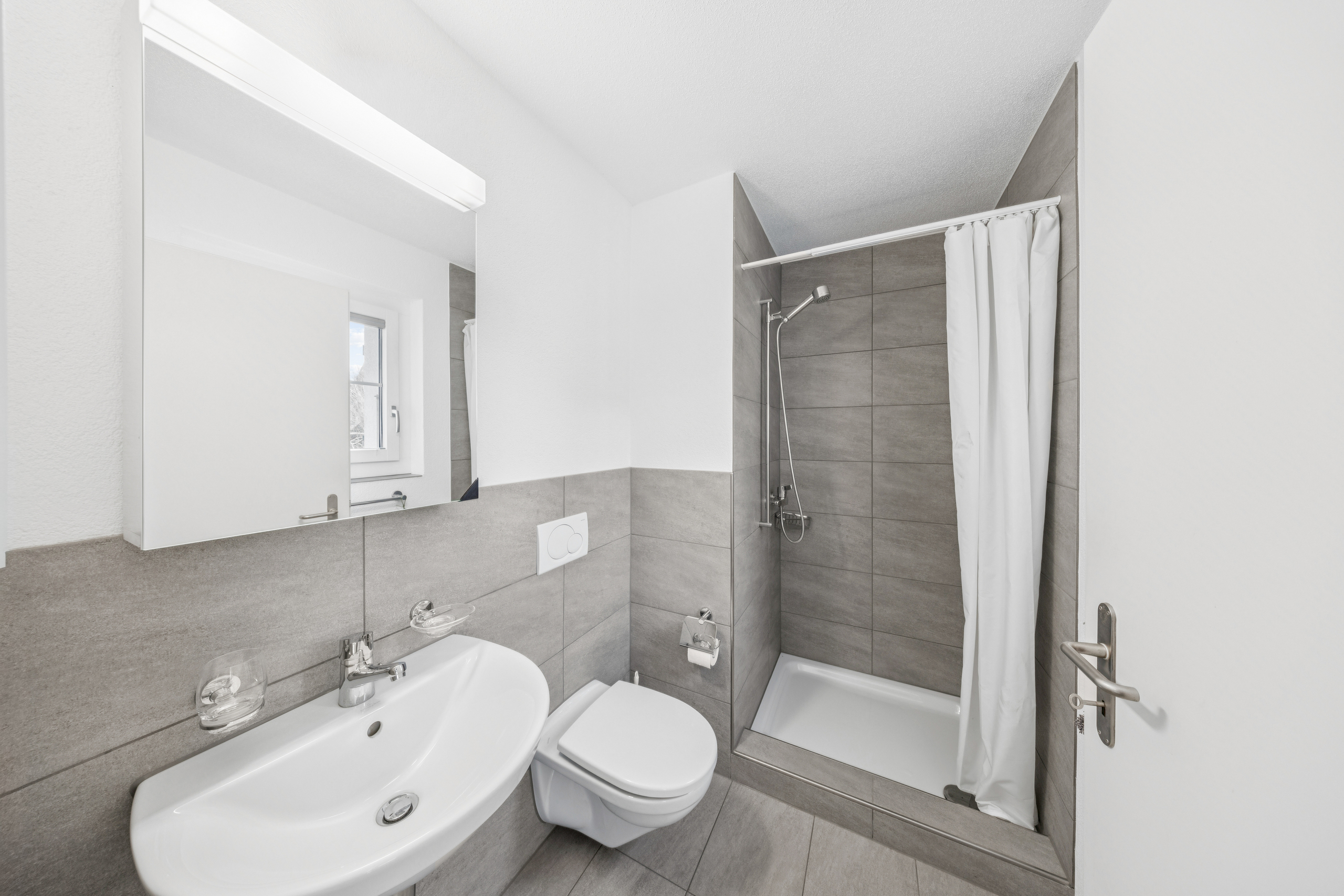Modernes Badezimmer mit Dusche, Waschbecken und WC