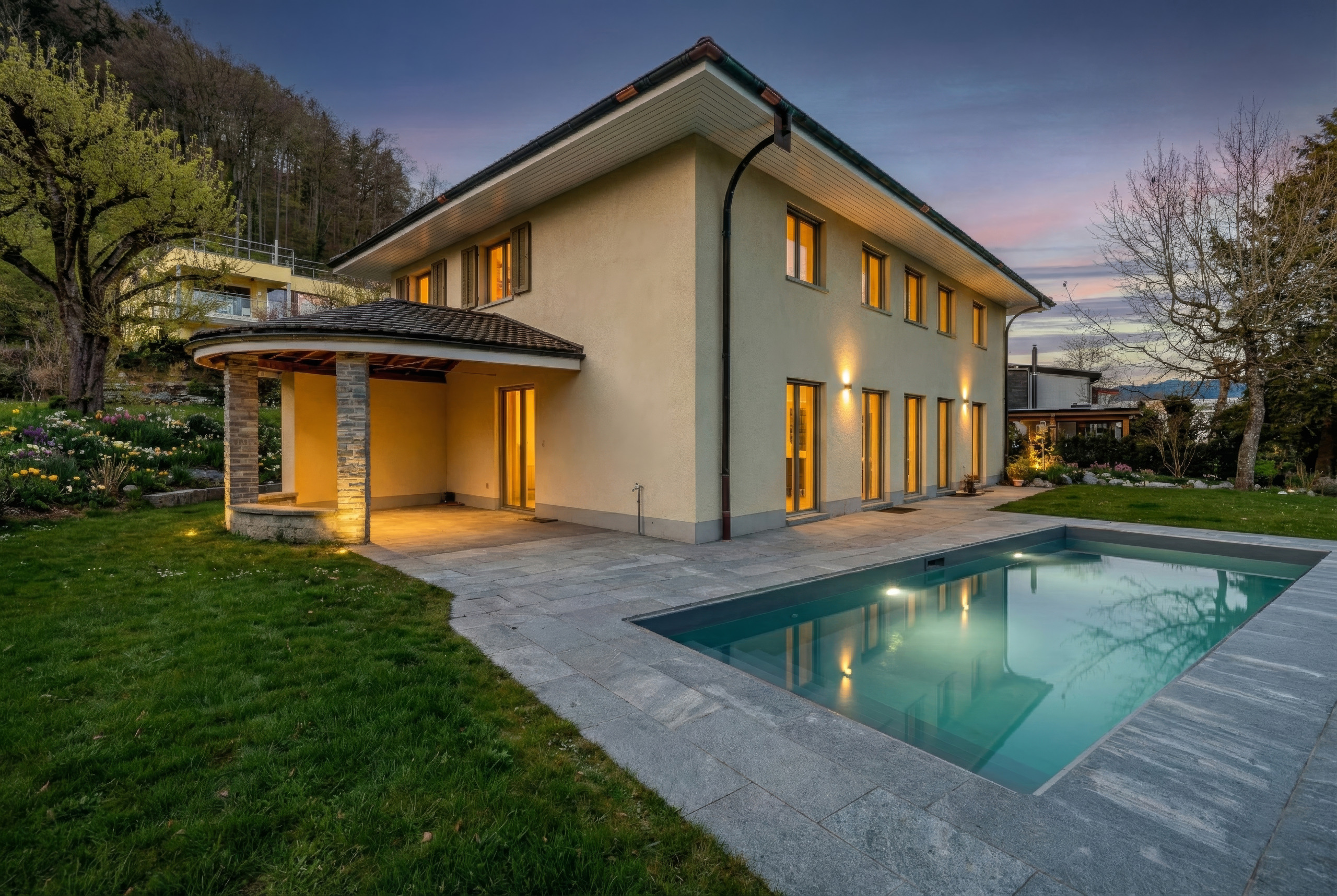 Moderne Villa mit Pool und Garten bei Abendlicht