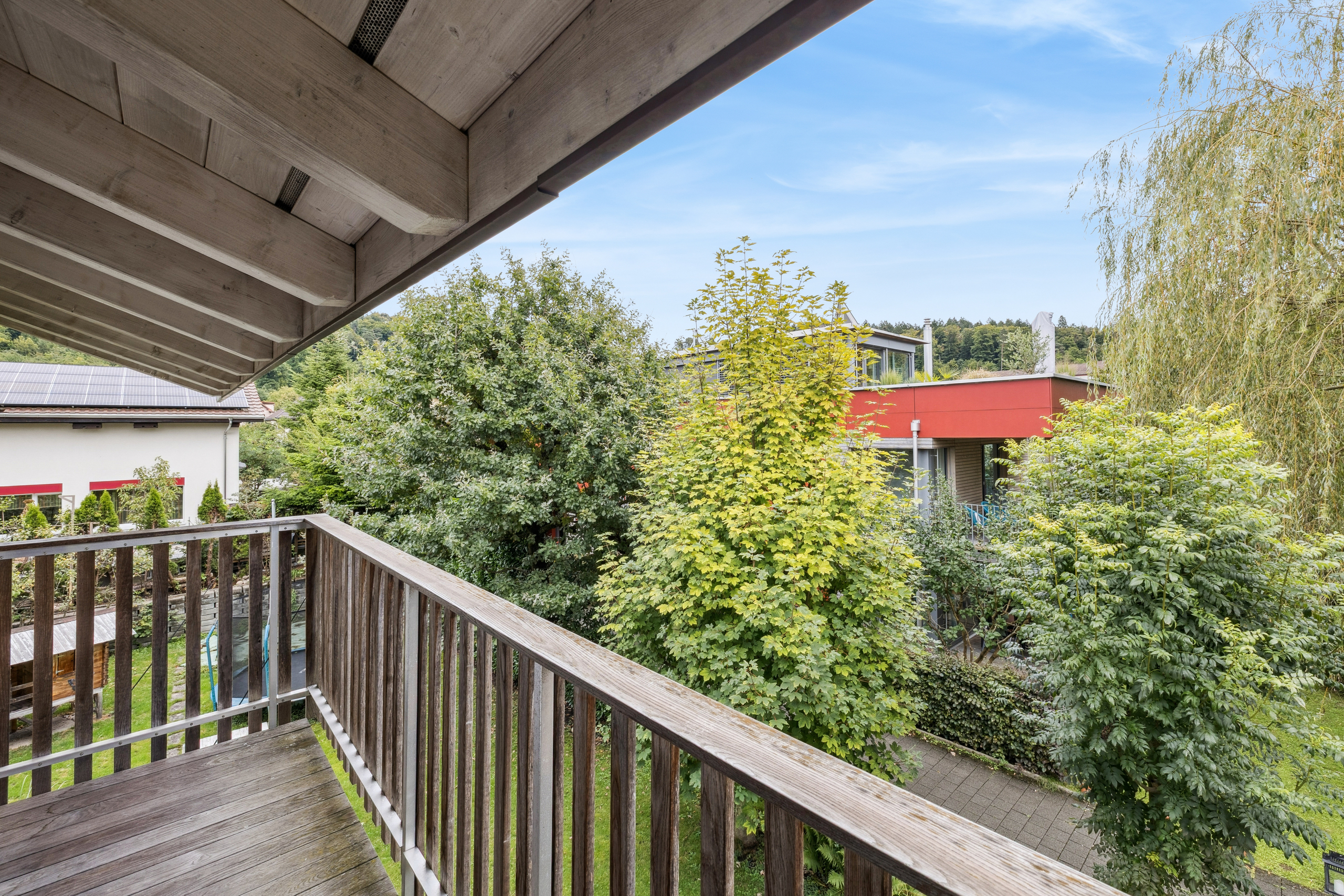 Balkon mit Holzgeländer und Gartenblick
