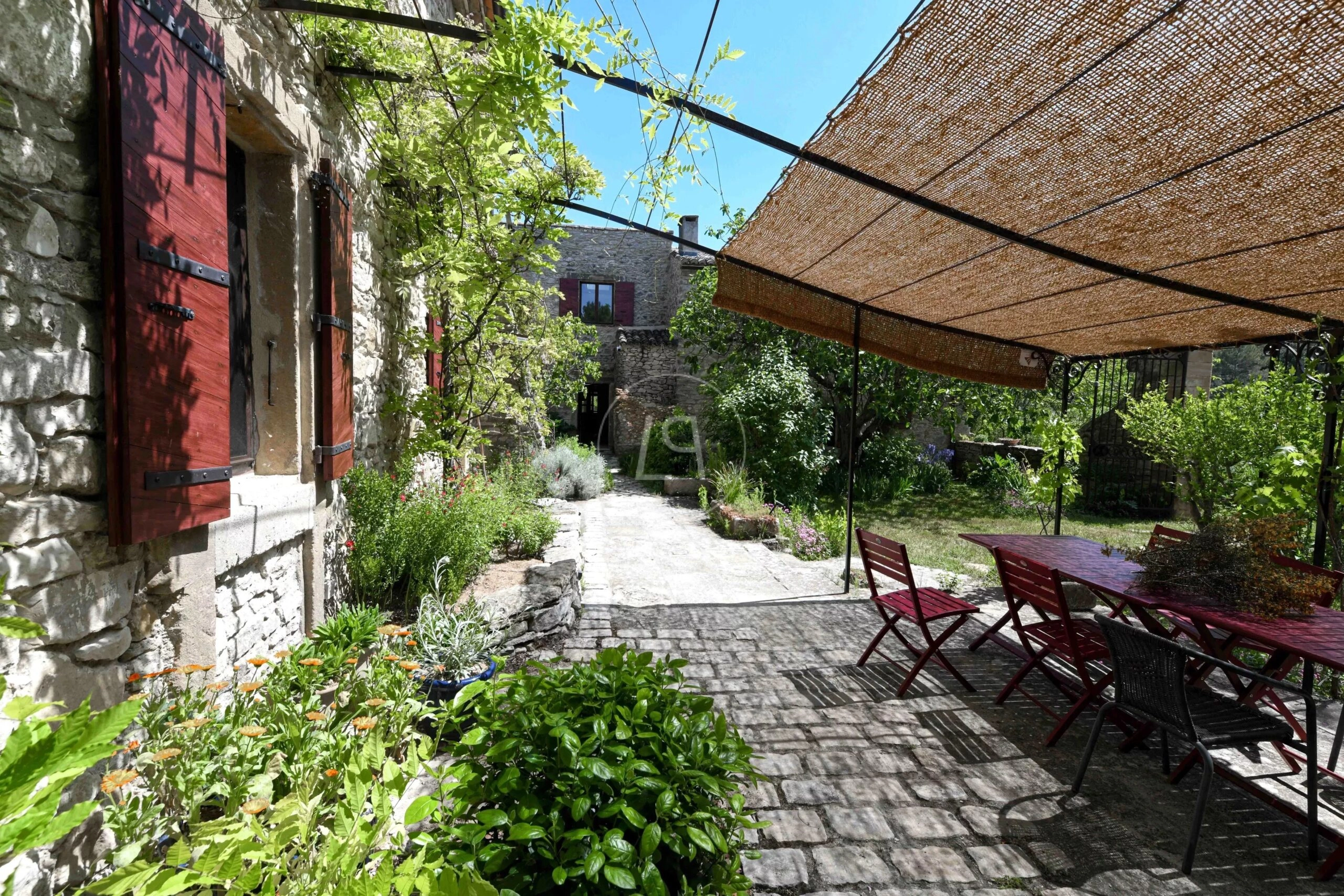 Mediterrane Steinterrasse mit Pergola und Gartenmöbeln