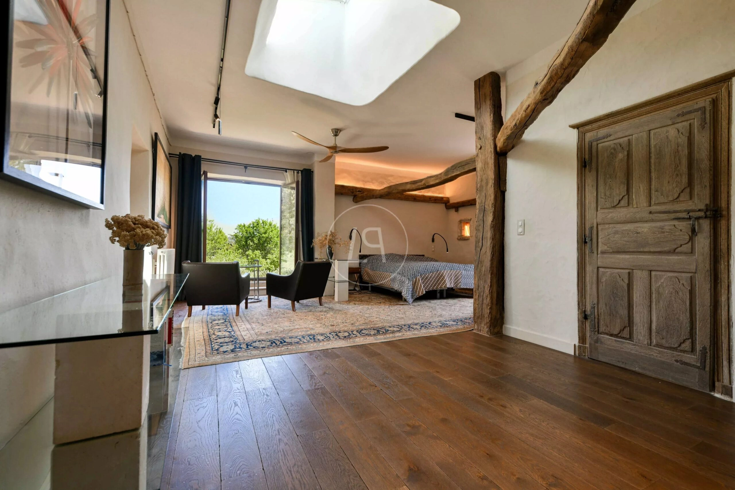 Rustikales Schlafzimmer mit sichtbaren Holzbalken und Gartenblick