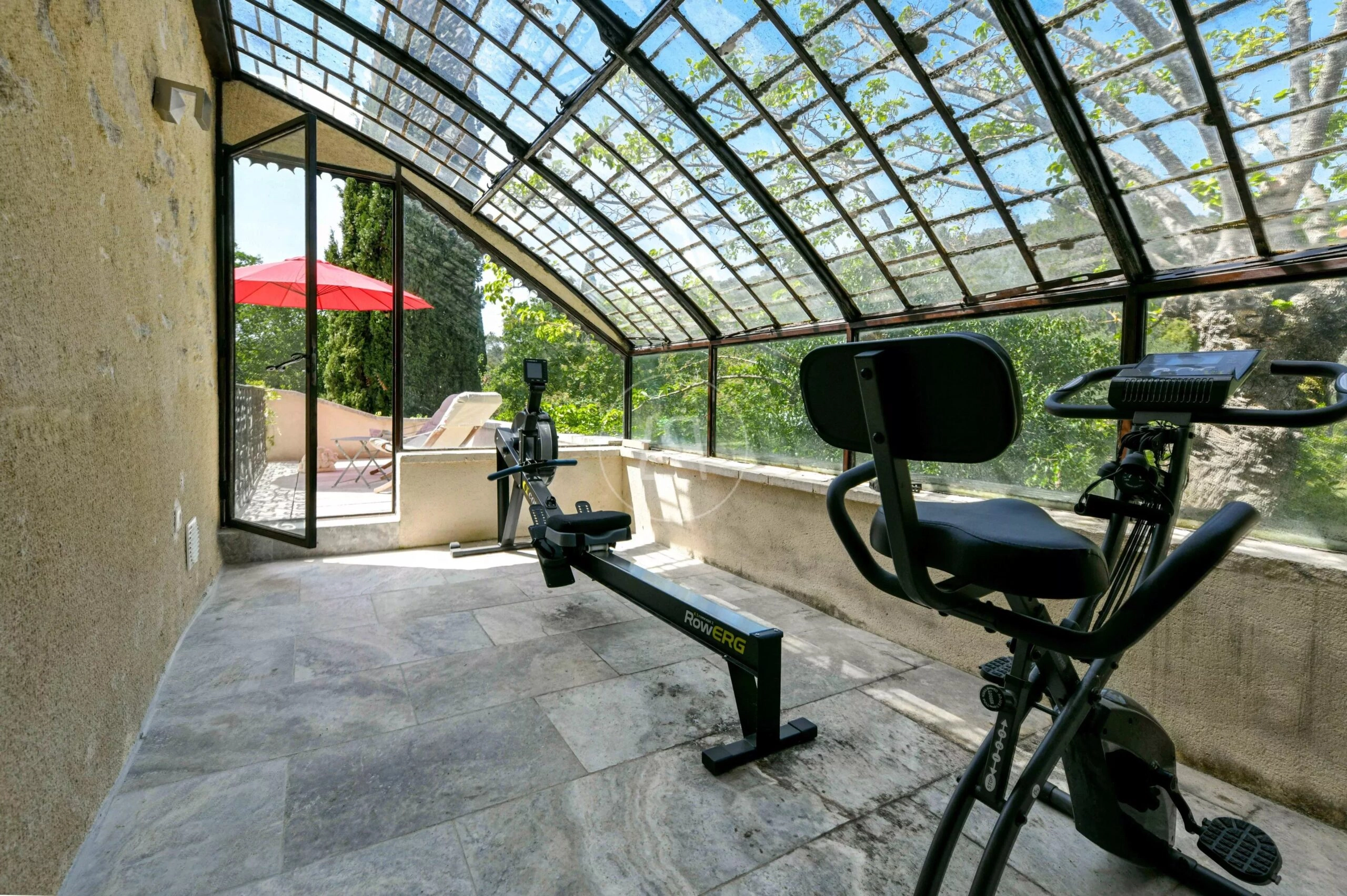 Verglaster Fitnessraum mit Terrasse