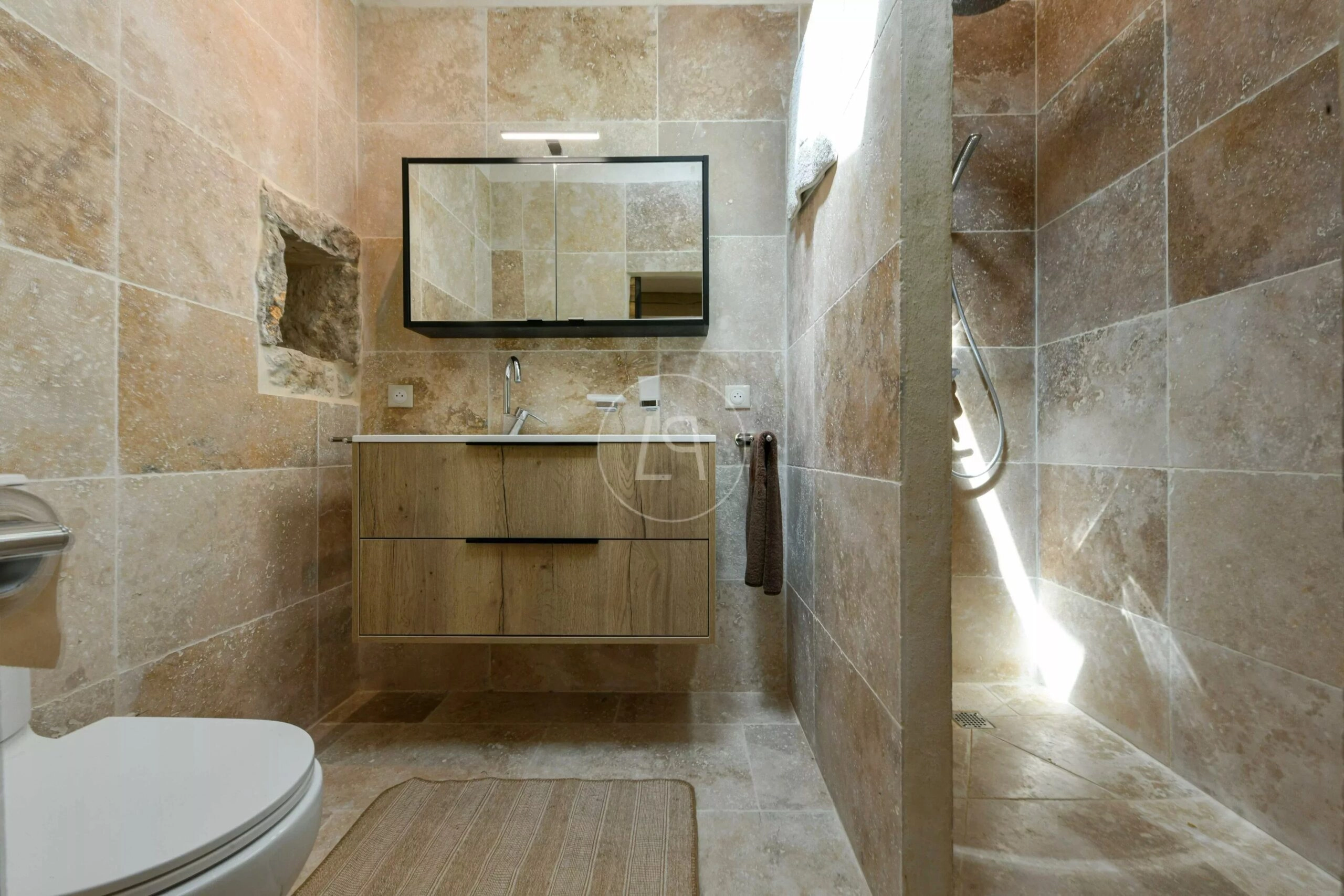 Luxuriöses Badezimmer mit Naturstein und Holzwaschtisch