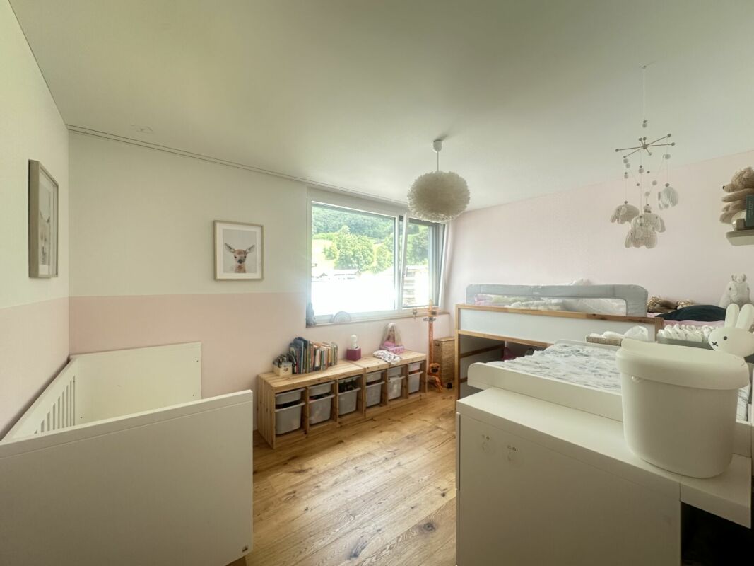 Kinderzimmer mit großem Fenster und Holzfußboden
