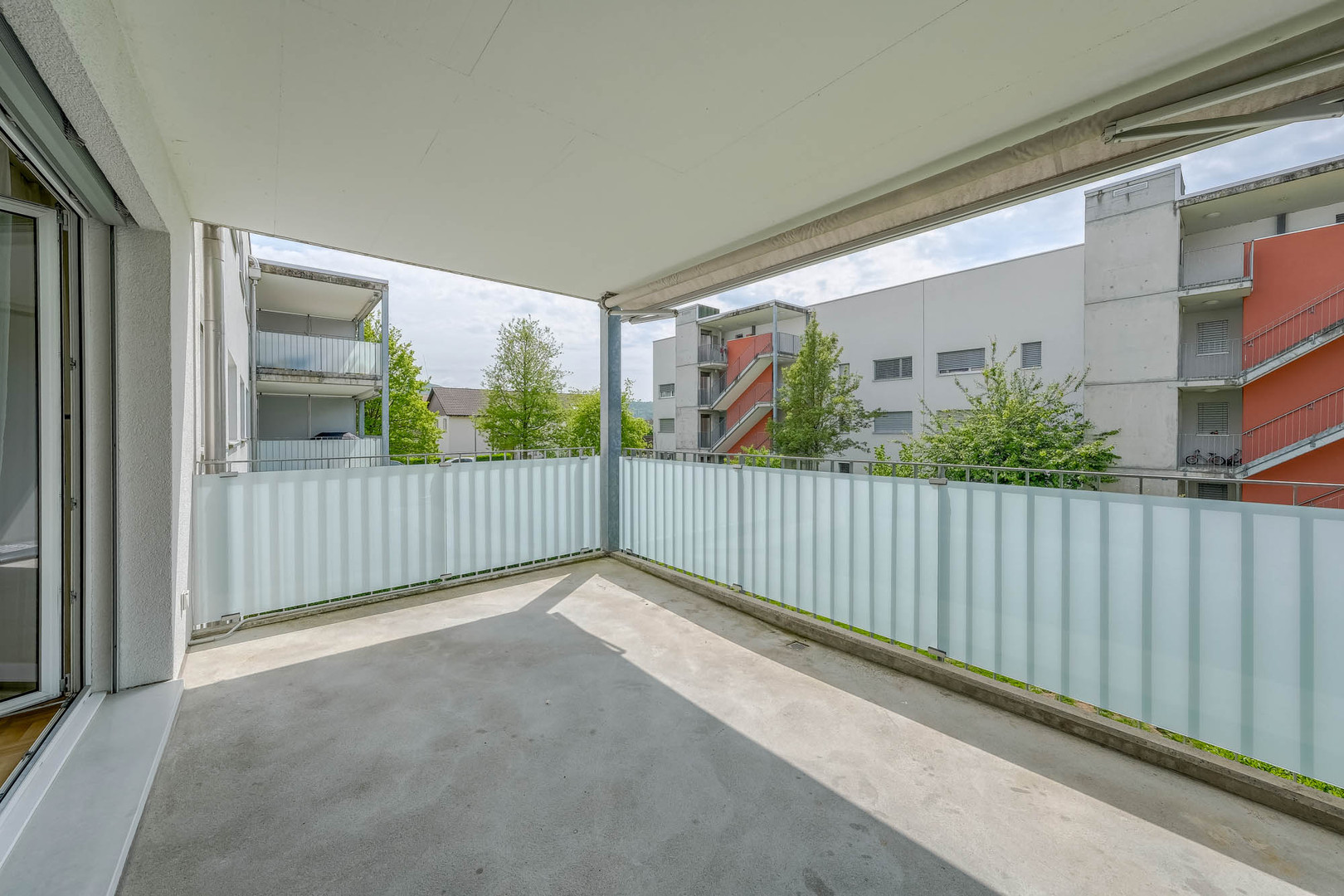Überdachter Balkon mit Blick auf Wohnanlage