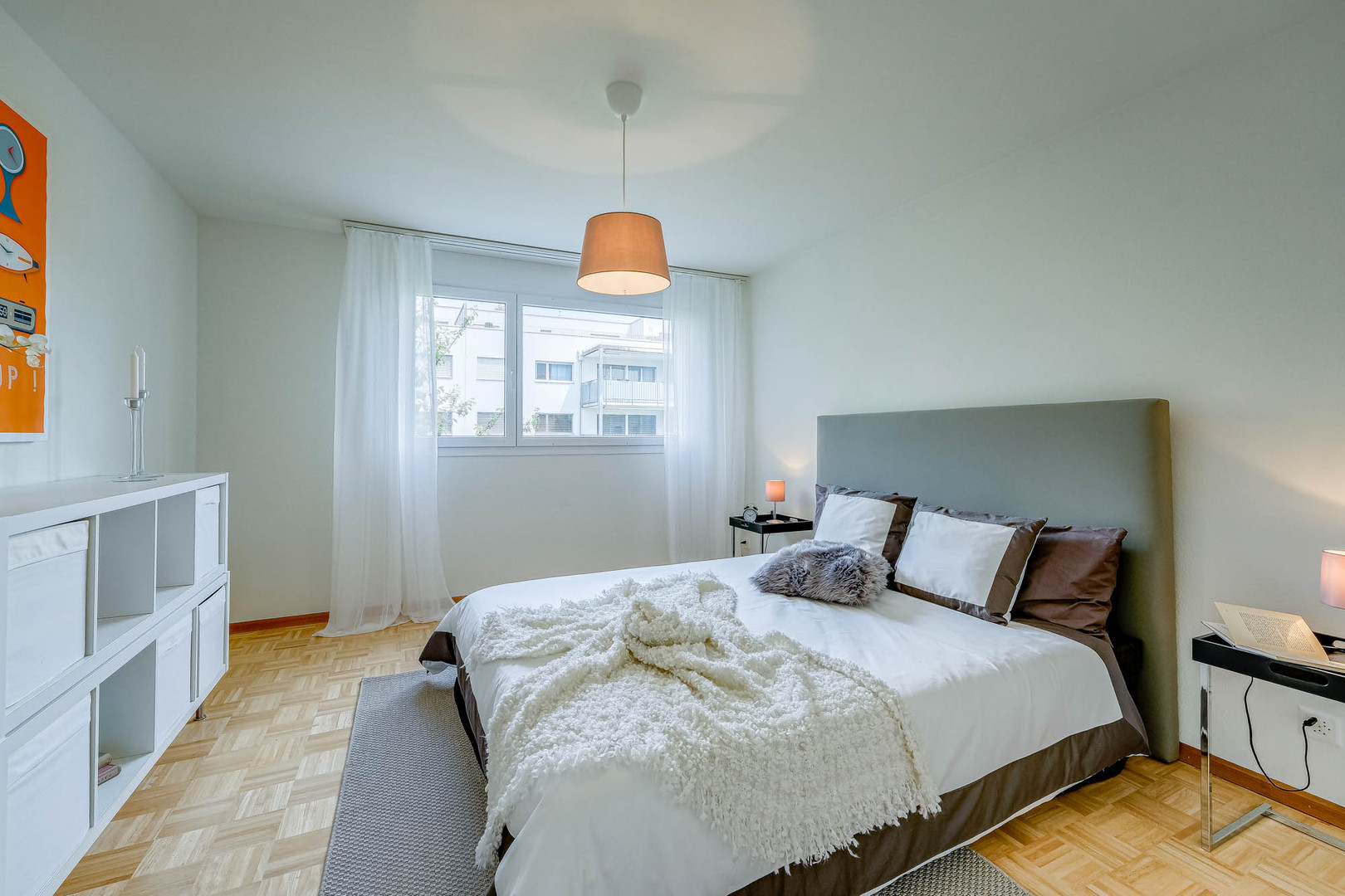 Helles Schlafzimmer mit Doppelbett und Fensterblick
