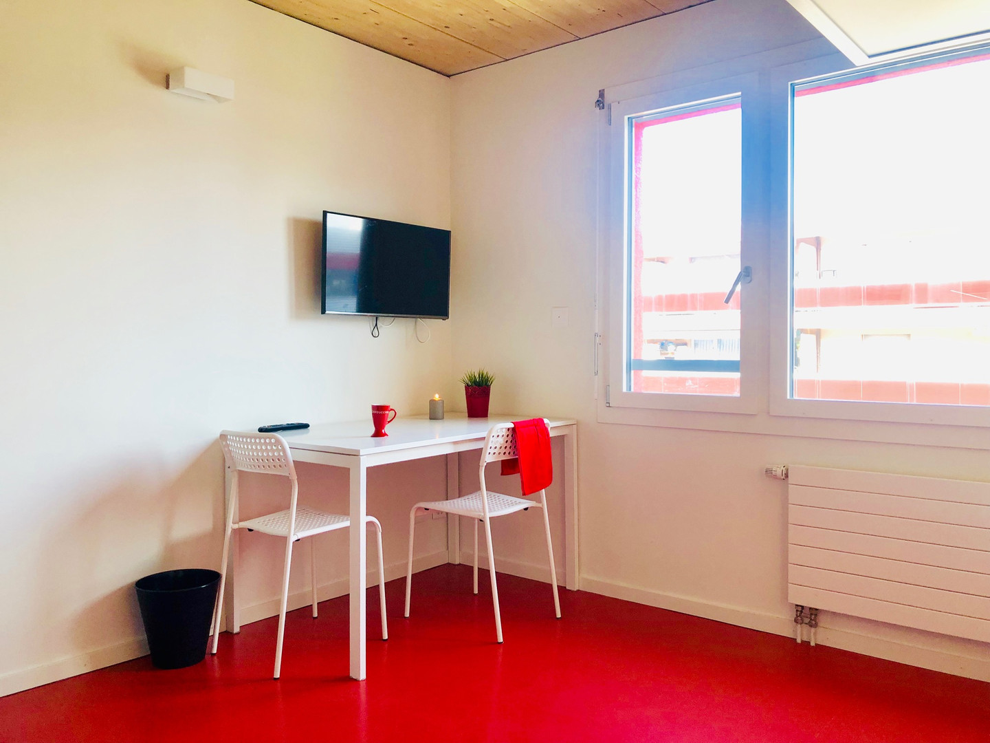 Helles, schlichtes Zimmer mit Schreibtisch und zwei Stühlen