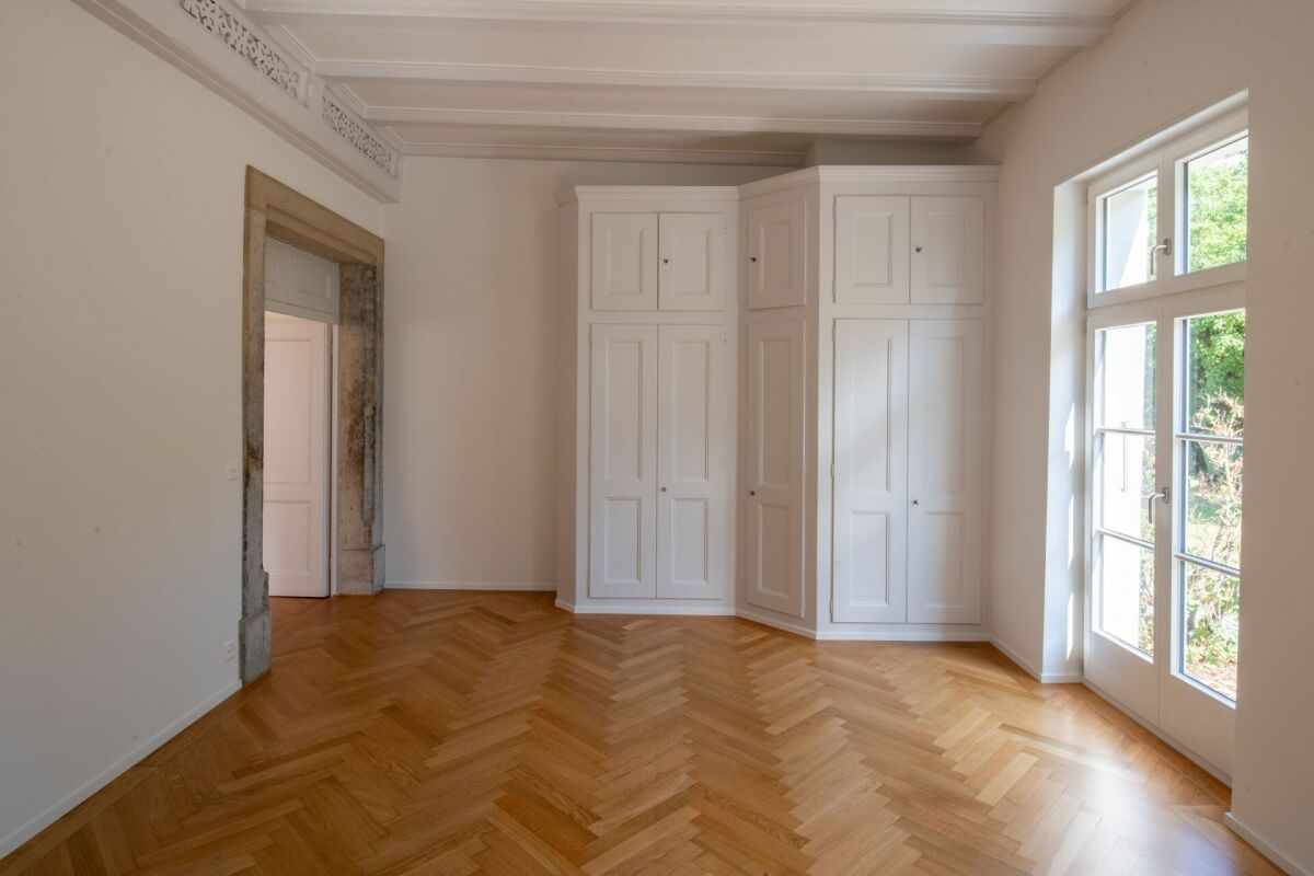 Heller Altbau-Raum mit Fischgrätparkett und Einbauschrank