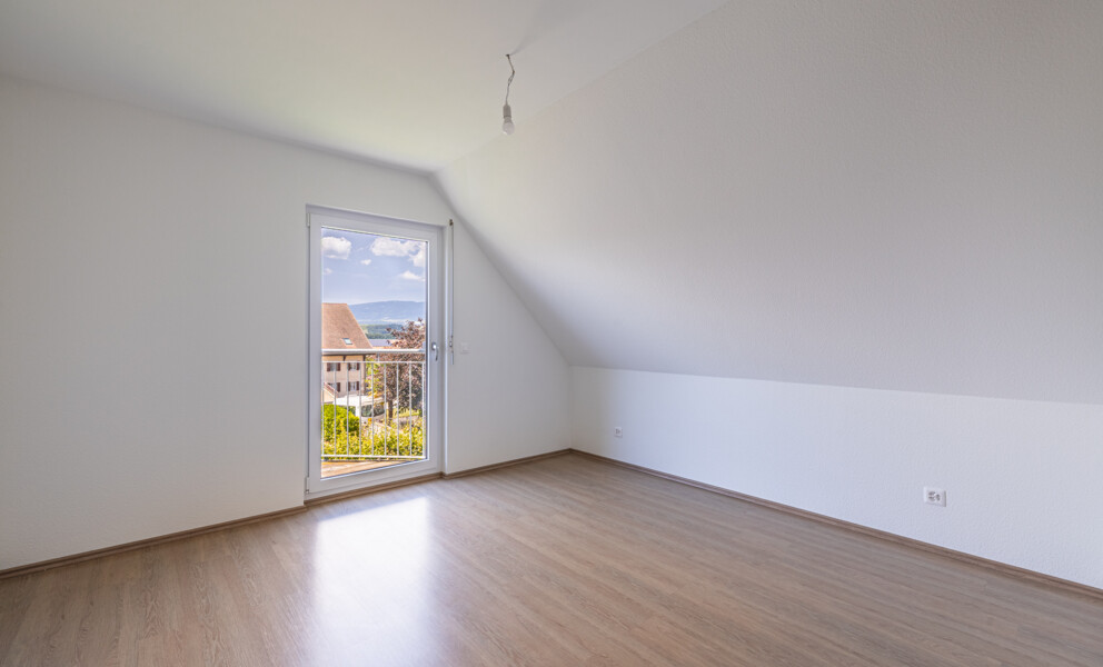 Leerer Dachraum mit Balkontür und Ausblick