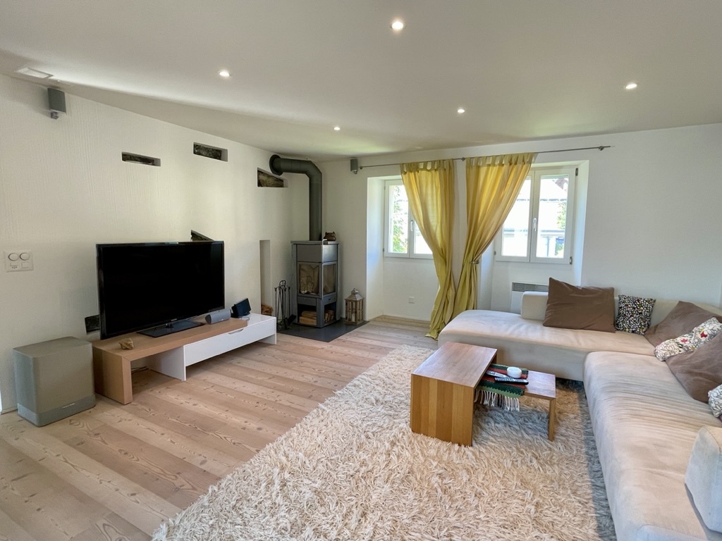 Helles Wohnzimmer mit Ecksofa und Holzofen