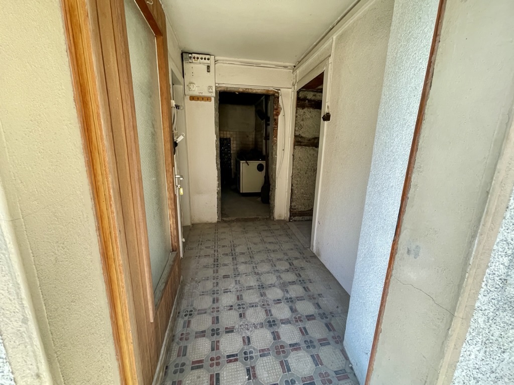 Schmaler Altbau-Flur mit Blick in Nebenräume