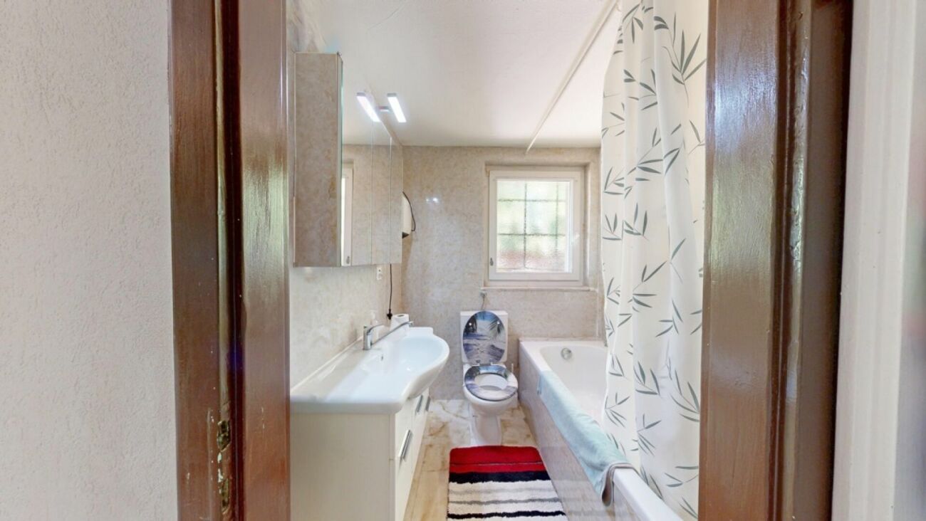 Badezimmer mit Badewanne und Waschplatz