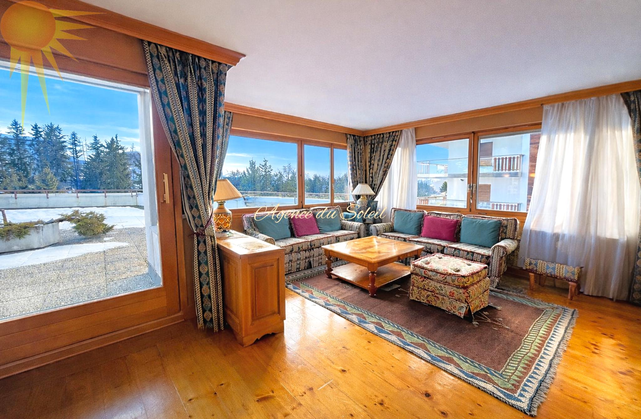 Helles Wohnzimmer mit Panoramafenstern und Sitzgruppe
