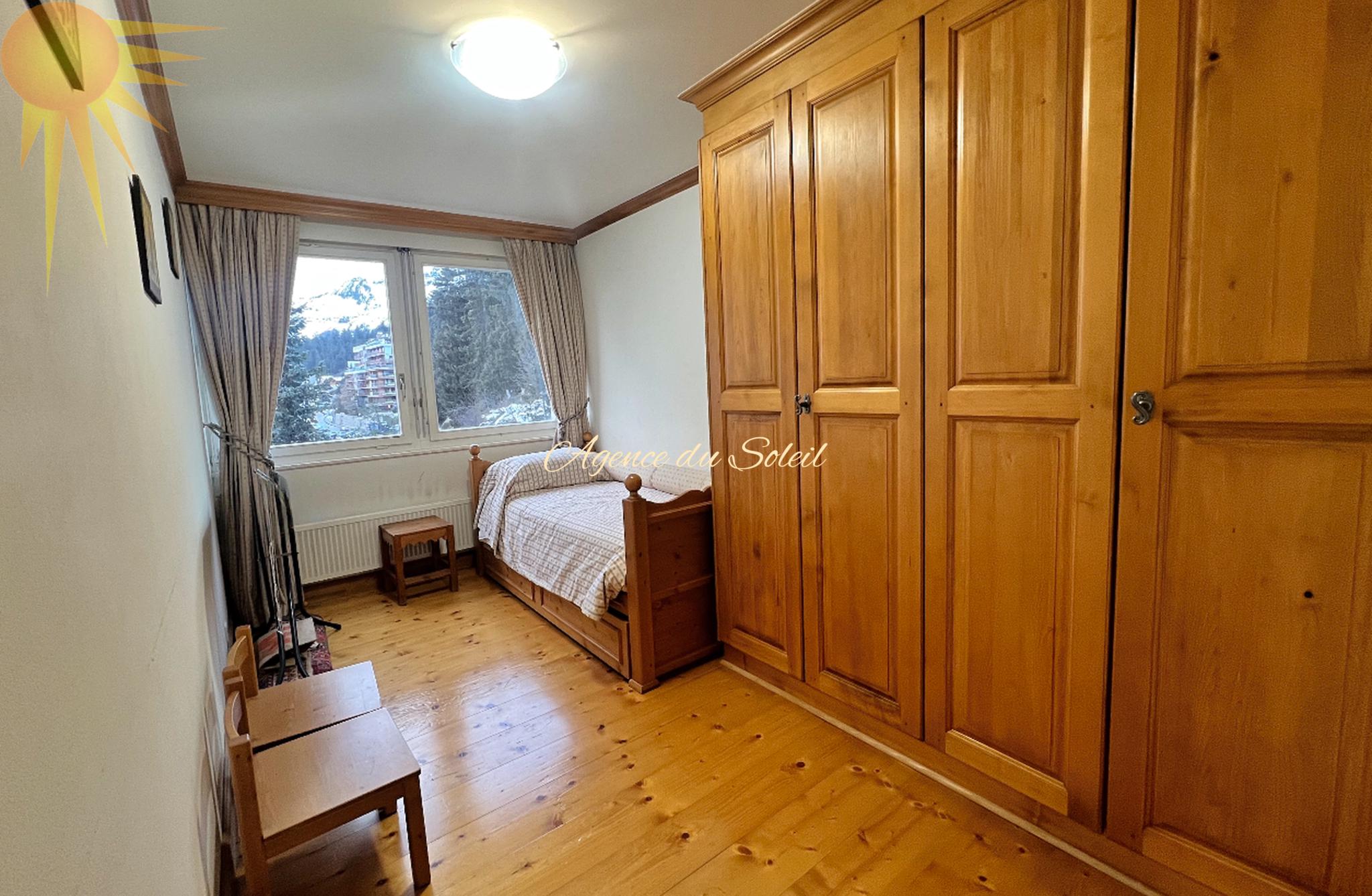 Gemütliches Schlafzimmer mit Holzschrank und Bergblick