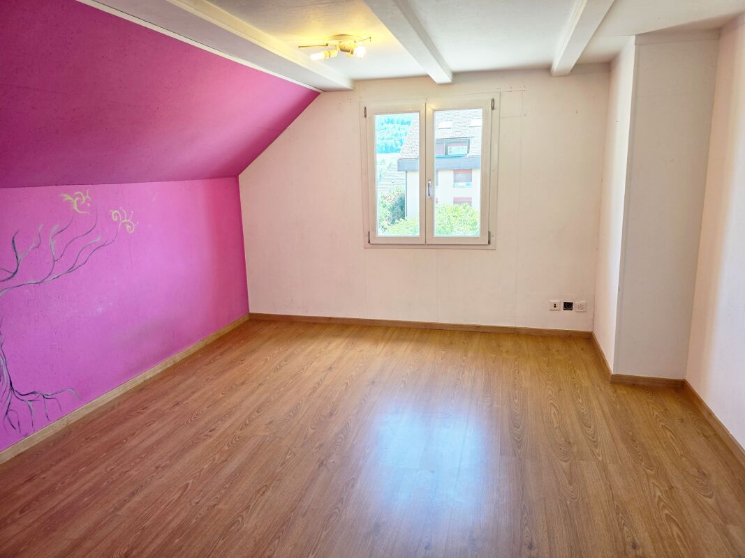 Leeres Dachzimmer mit pinker Akzentwand