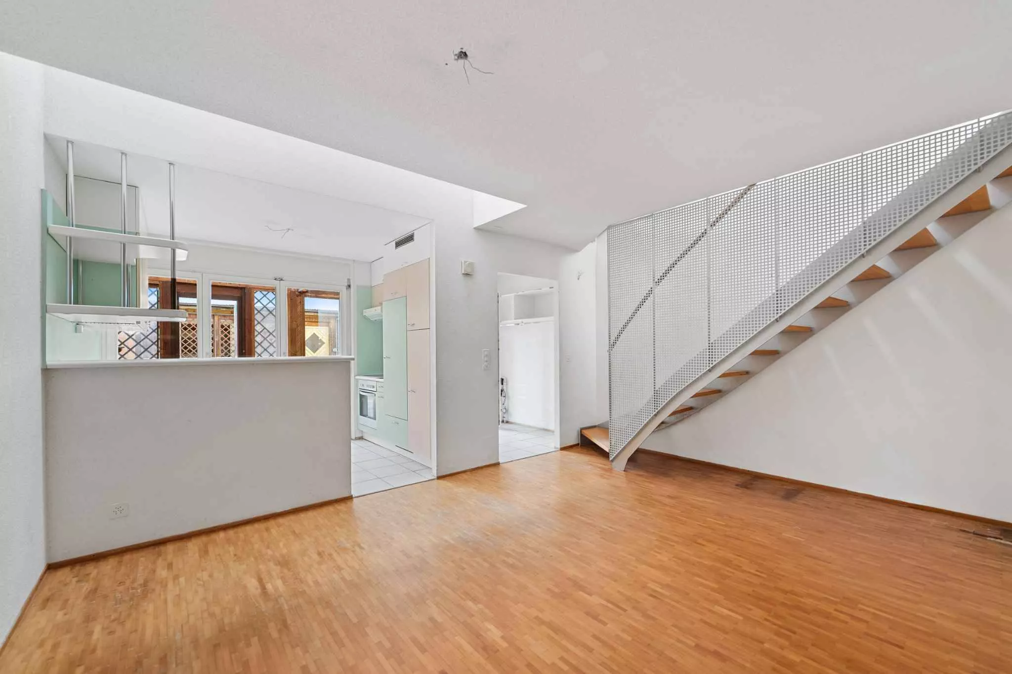 Heller Wohnraum mit Treppe und Küchenbereich