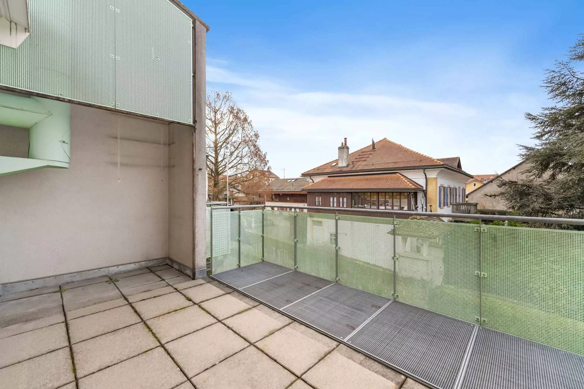 Balkon mit Glasgeländer und Nachbarschaftsansicht