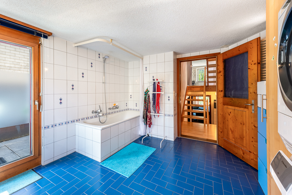 Badezimmer mit blauem Boden und Holzdetails