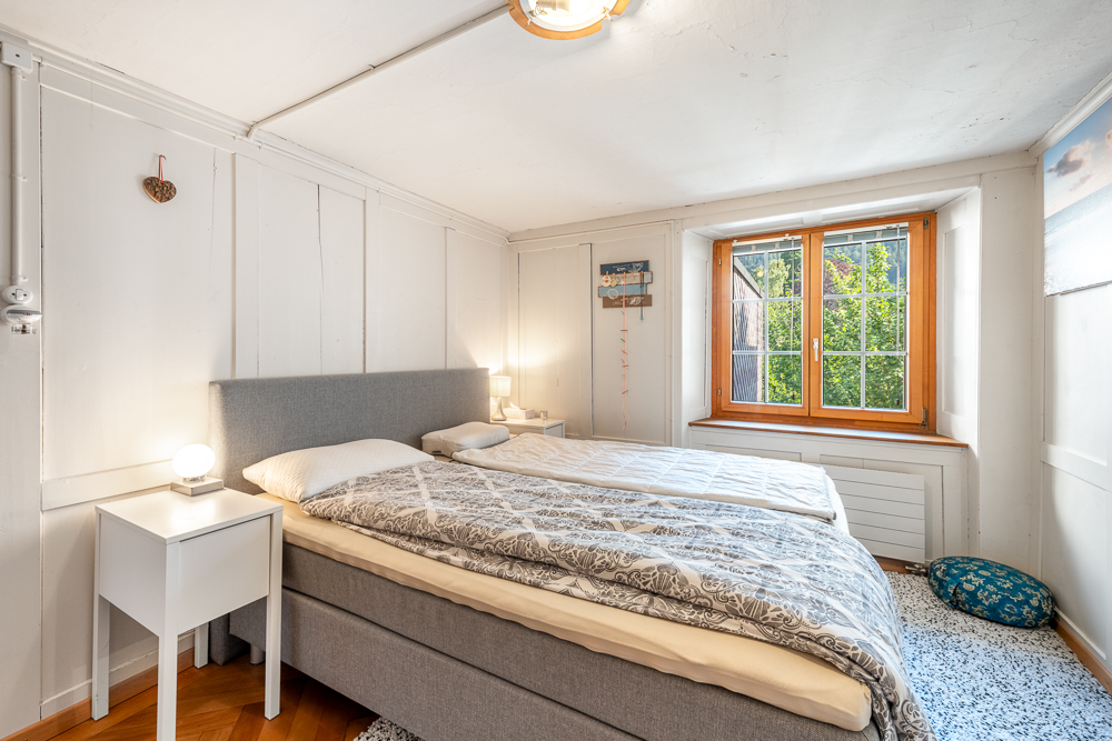 Helles Schlafzimmer mit Holzwand und Einzelbett