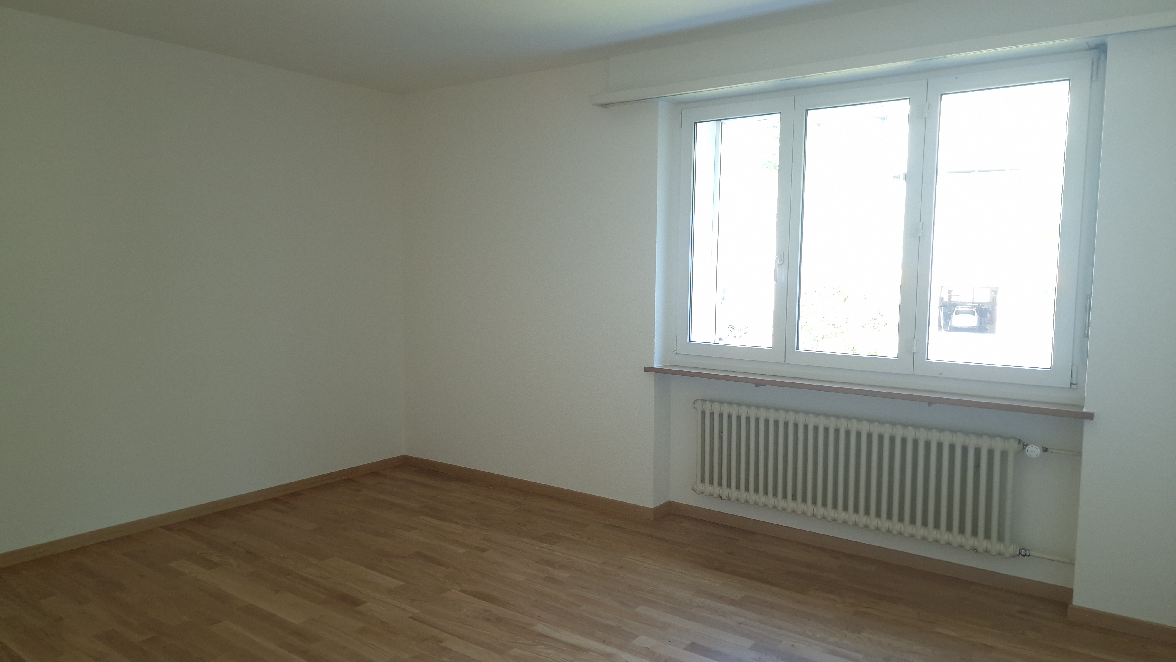 Heller leerer Raum mit Fenster und Heizkörper