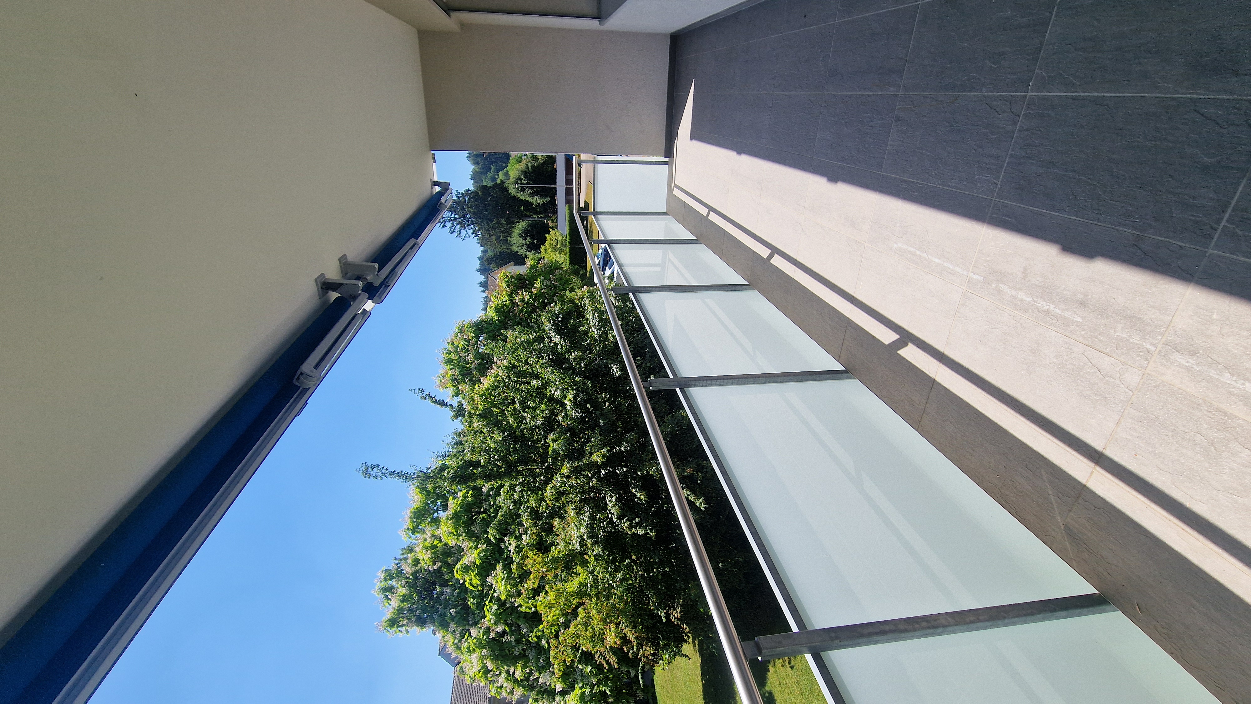 Balkon mit Glasgeländer und Blick ins Grüne