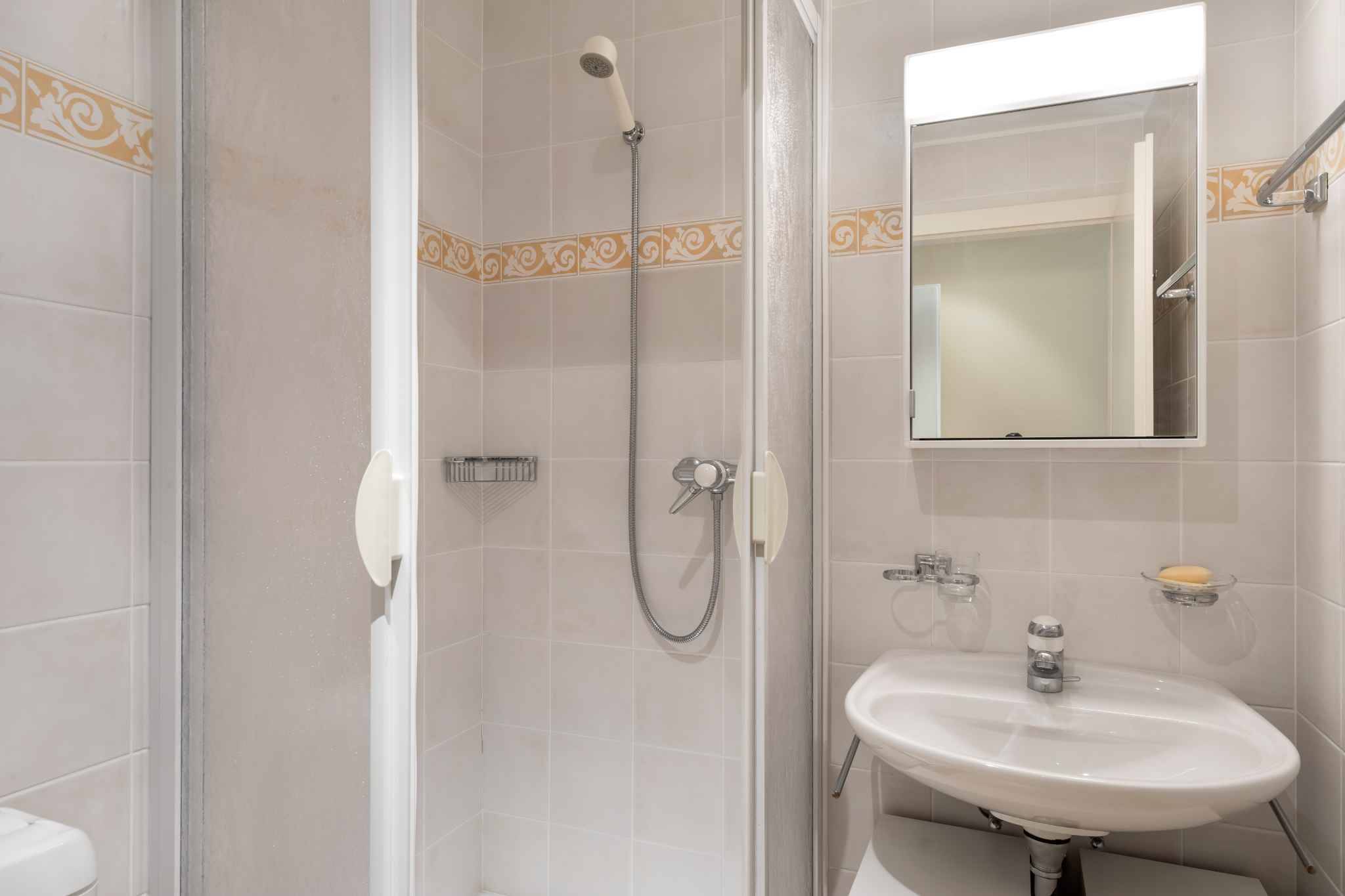 Badezimmer mit Duschkabine und Waschbecken