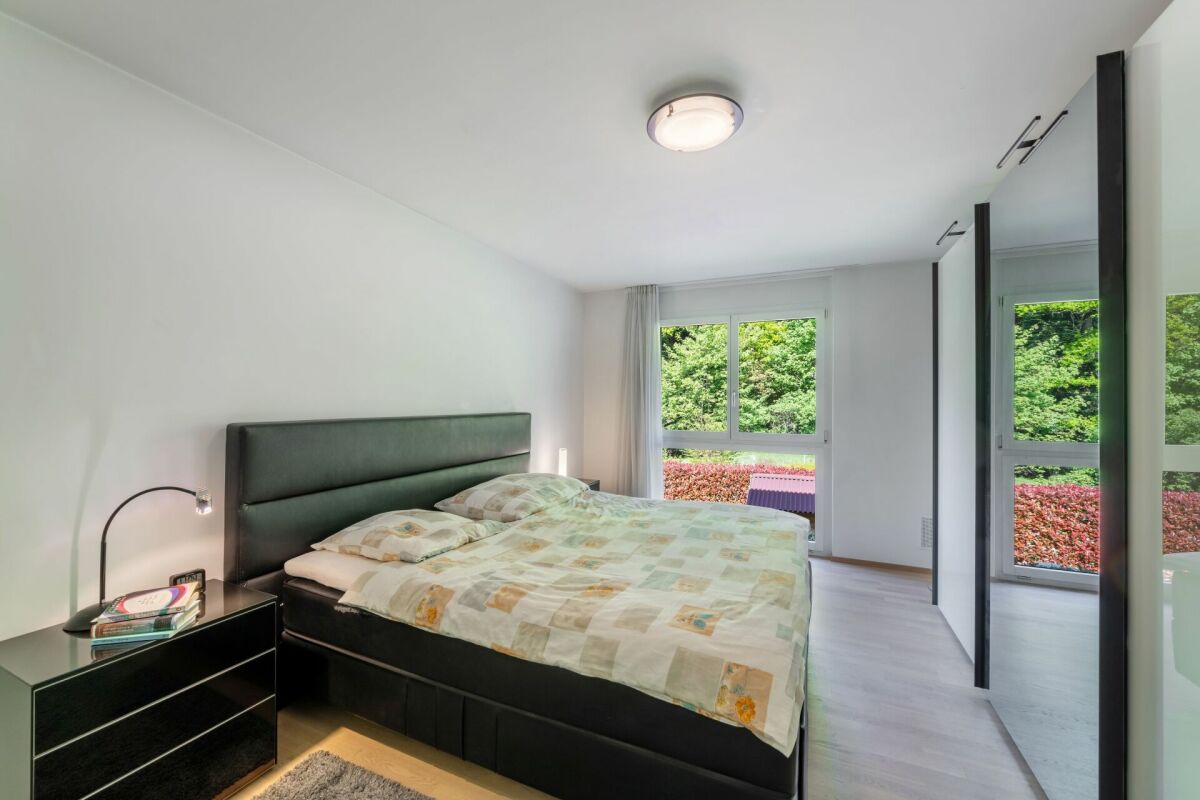 Modernes Schlafzimmer mit großem Fenster und Spiegelkleiderschrank