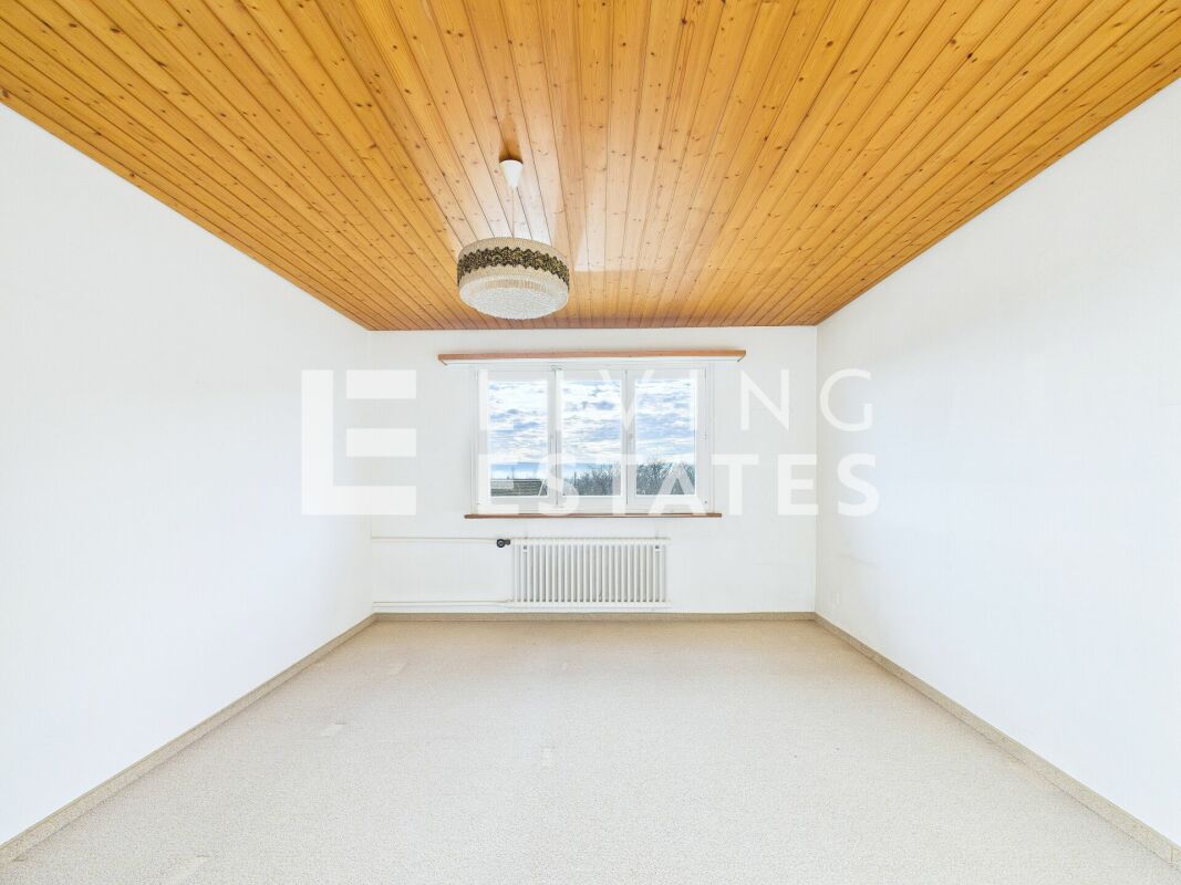 Heller leerer Raum mit Holzdecke und Fenster