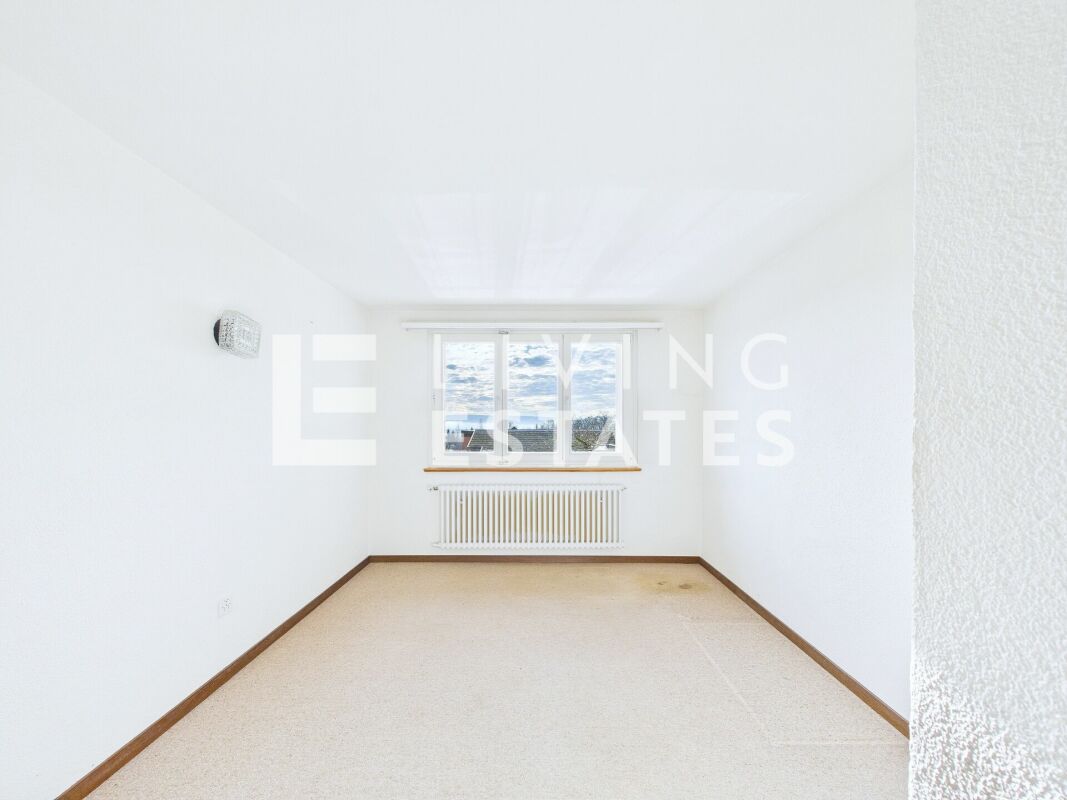 Leerer heller Raum mit Fenster und Heizkörper
