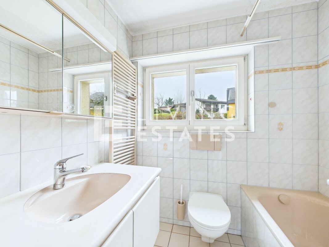 Helles Badezimmer mit Fenster, Waschbecken, WC und Badewanne