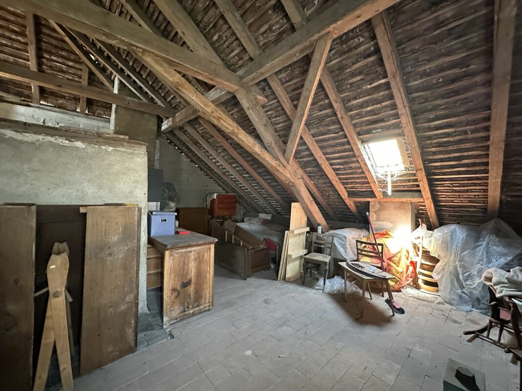 Dachboden mit sichtbarem Holztragwerk und gelagerten Möbeln